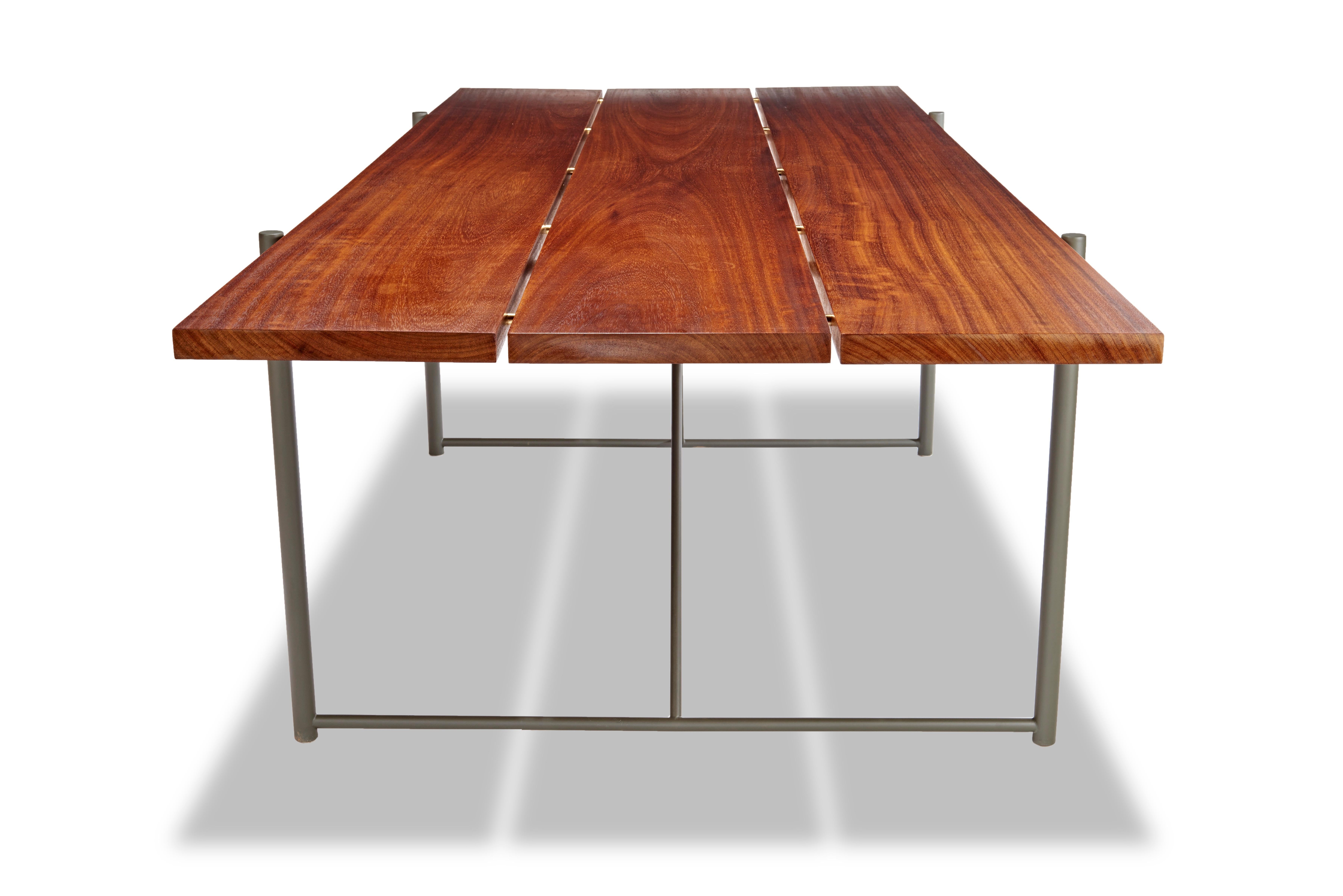 Table de salle à manger Ten10 en teck massif huilé avec des chevilles en laiton et une base en acier inoxydable peinte par poudrage en vert Yuma. Également disponible en noir mat ou en bronze frotté à l'huile. Convient à une utilisation intérieure