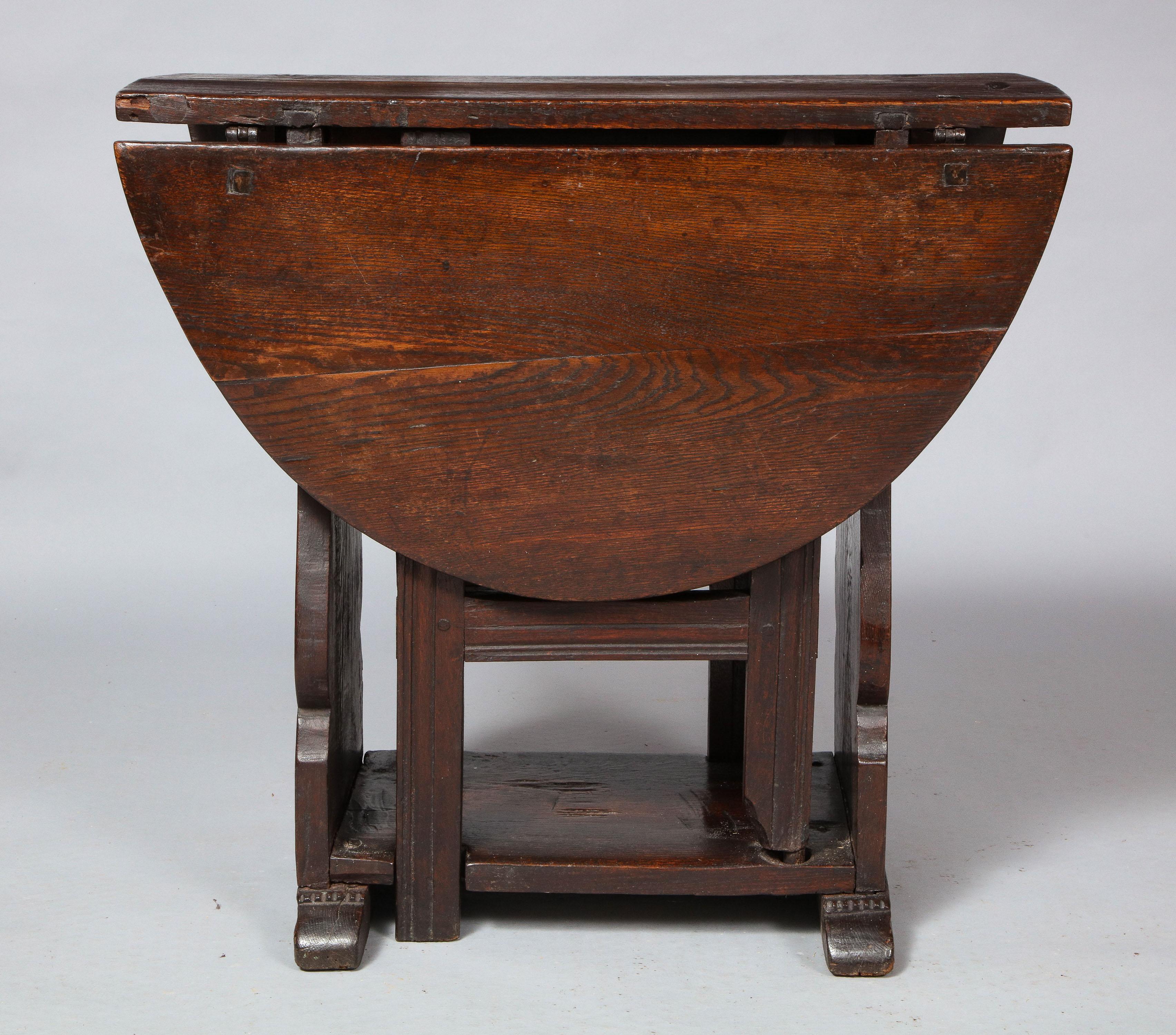 Good late 17th century English or Welsh oak gateleg table, the oval top over balustrade silhouette slap ends, one with drawer, the swing legs of simple boarded construction, standing on shaped shoe feet, the whole possessing good rich color and