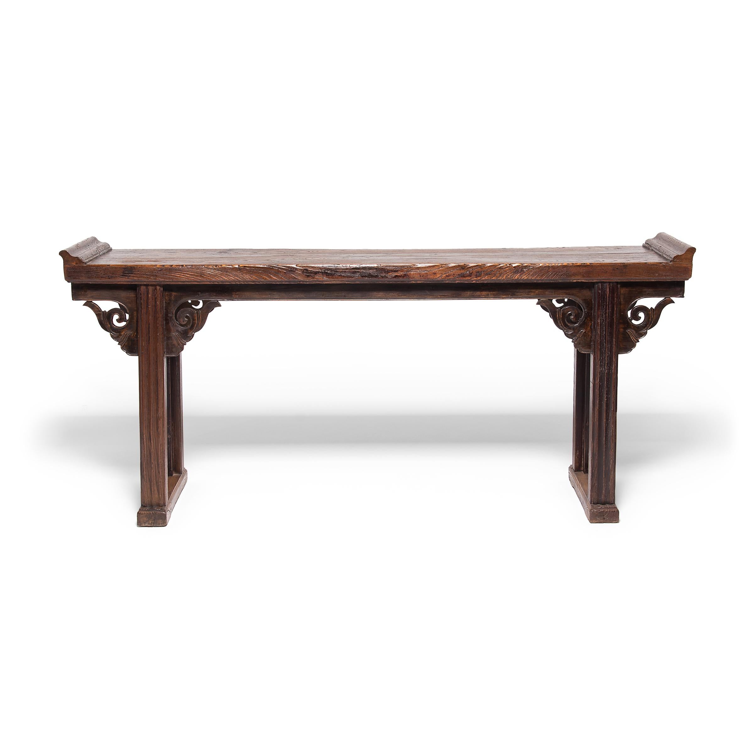 With everted ends and square legs, this altar table expresses Classic Qing-dynasty design, but the hand-carved spandrels are extraordinary and truly set the design apart. Trimmed with a finely beaded edge, the spandrels are carved with a scrolled