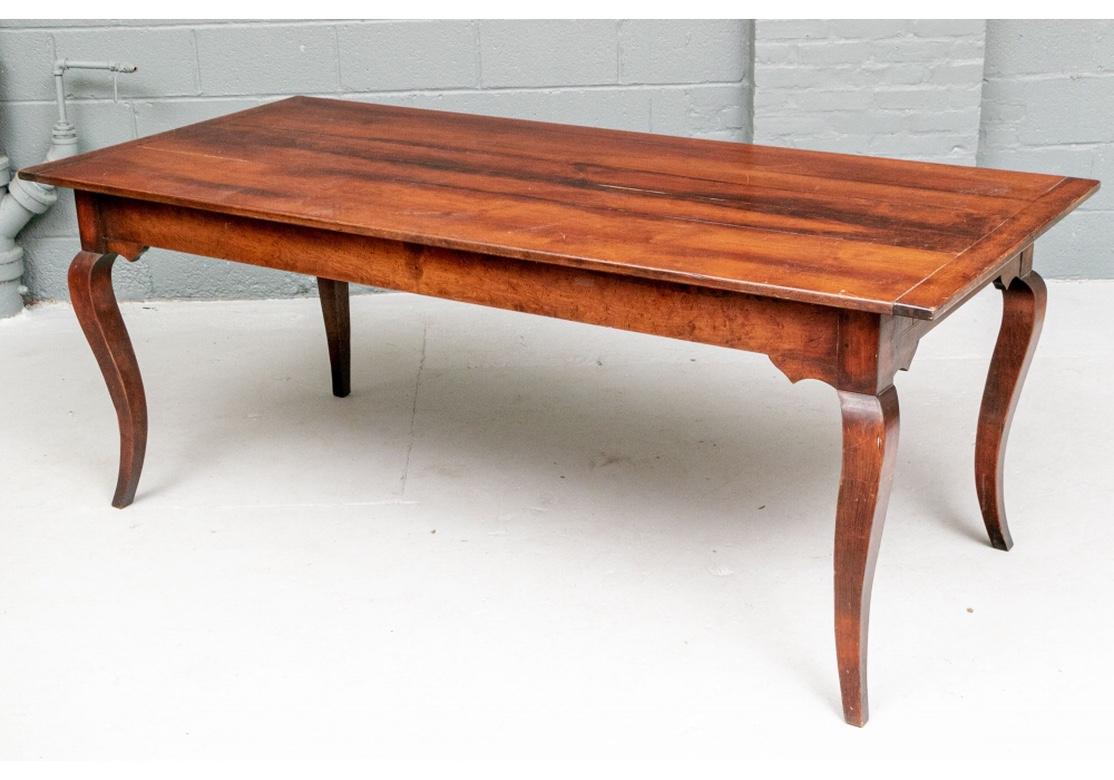 Wide plank top cherry dining table with bread board ends and drawers on each end. Spandrels on the apron ends near the cabriole legs. 
Measures: 78