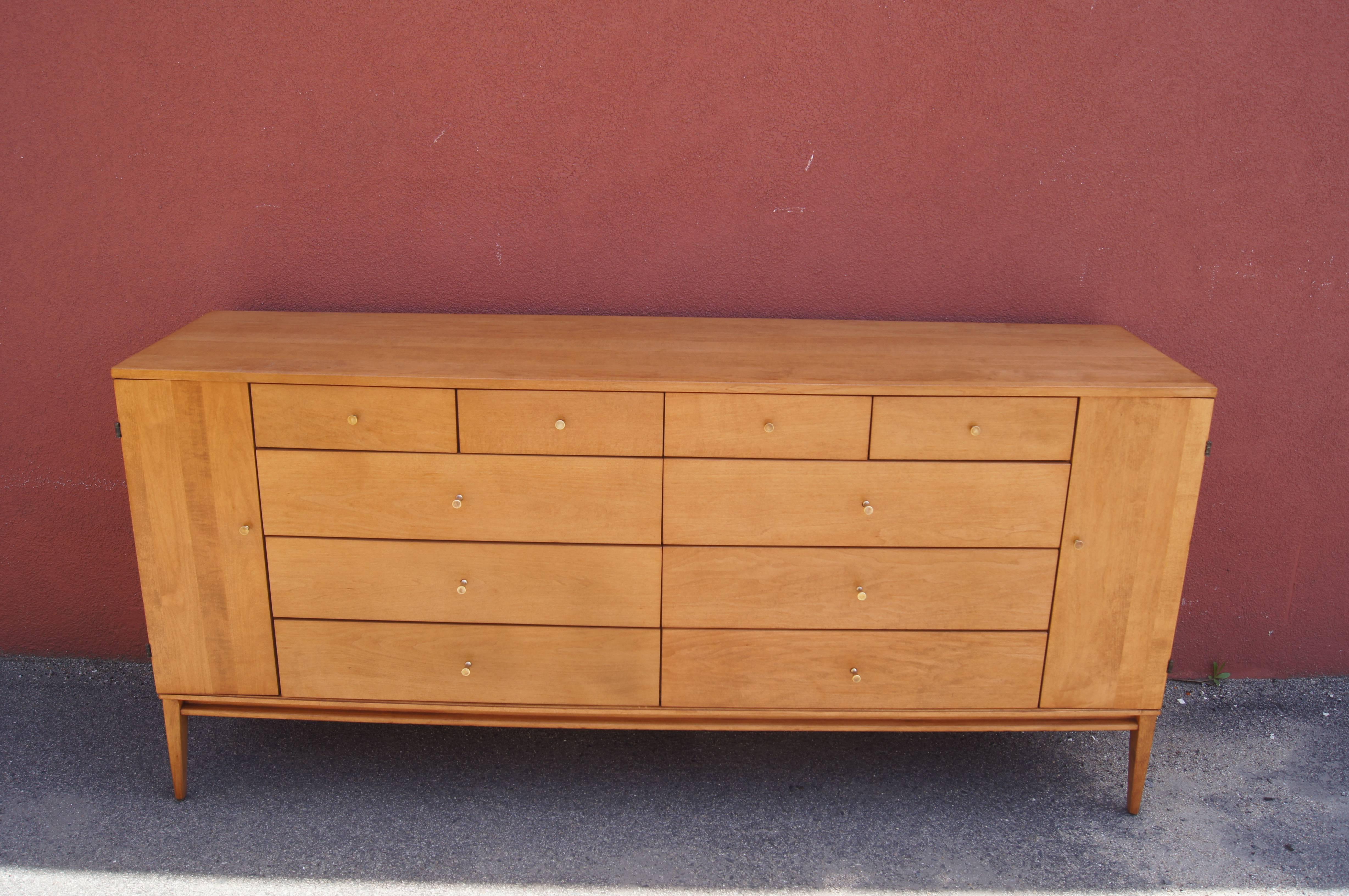 Paul McCobb designed this fabulous twenty-drawer dresser, model #1510, as part of the Planner Group by Winchendon. It features a maple case with four drawers above two banks of three wider drawers, flanked on each side by narrow cabinet doors that
