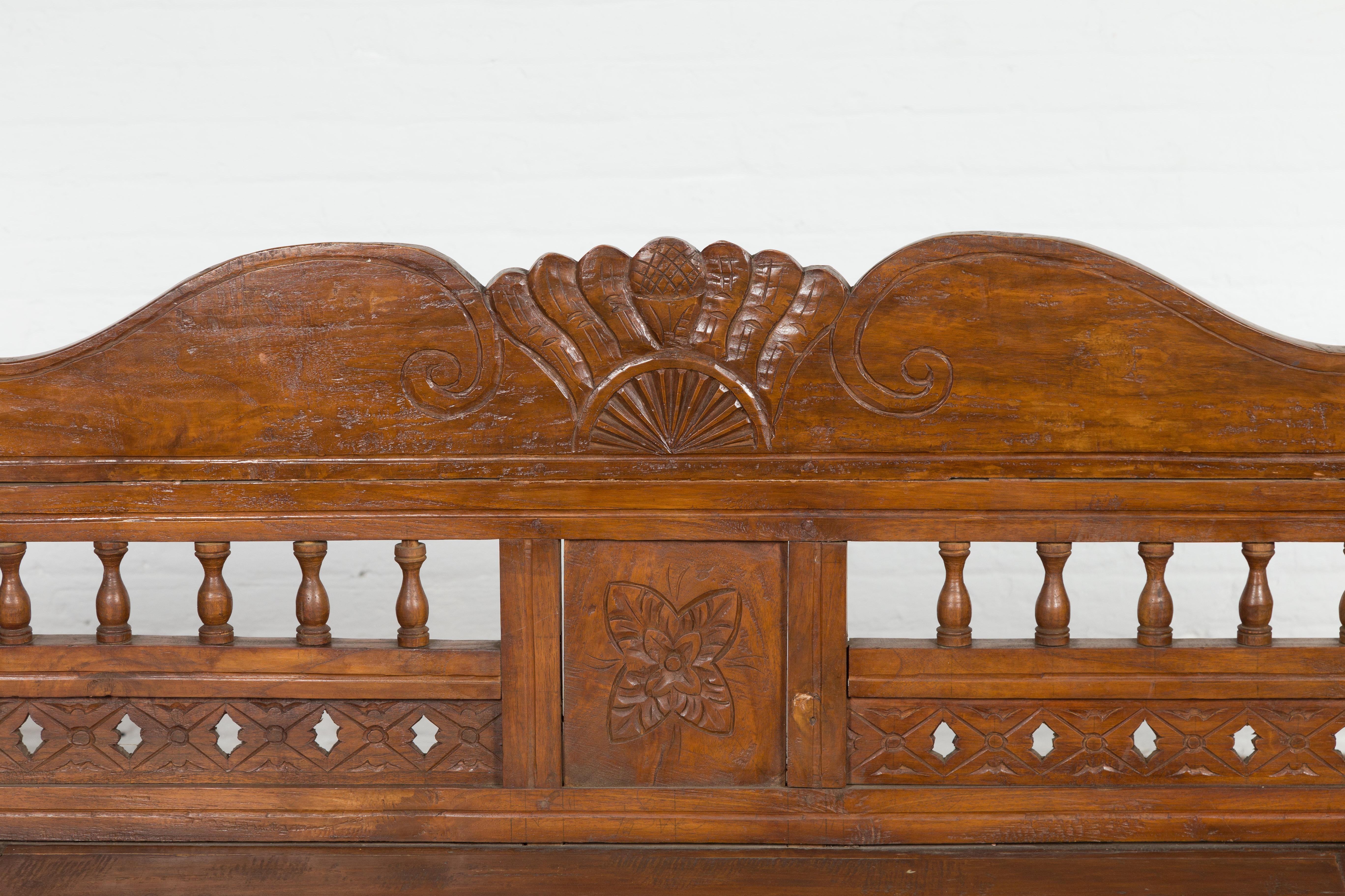 20th Century Javanese Teak Settee with Carved Décor and Out-Scrolling Arms For Sale