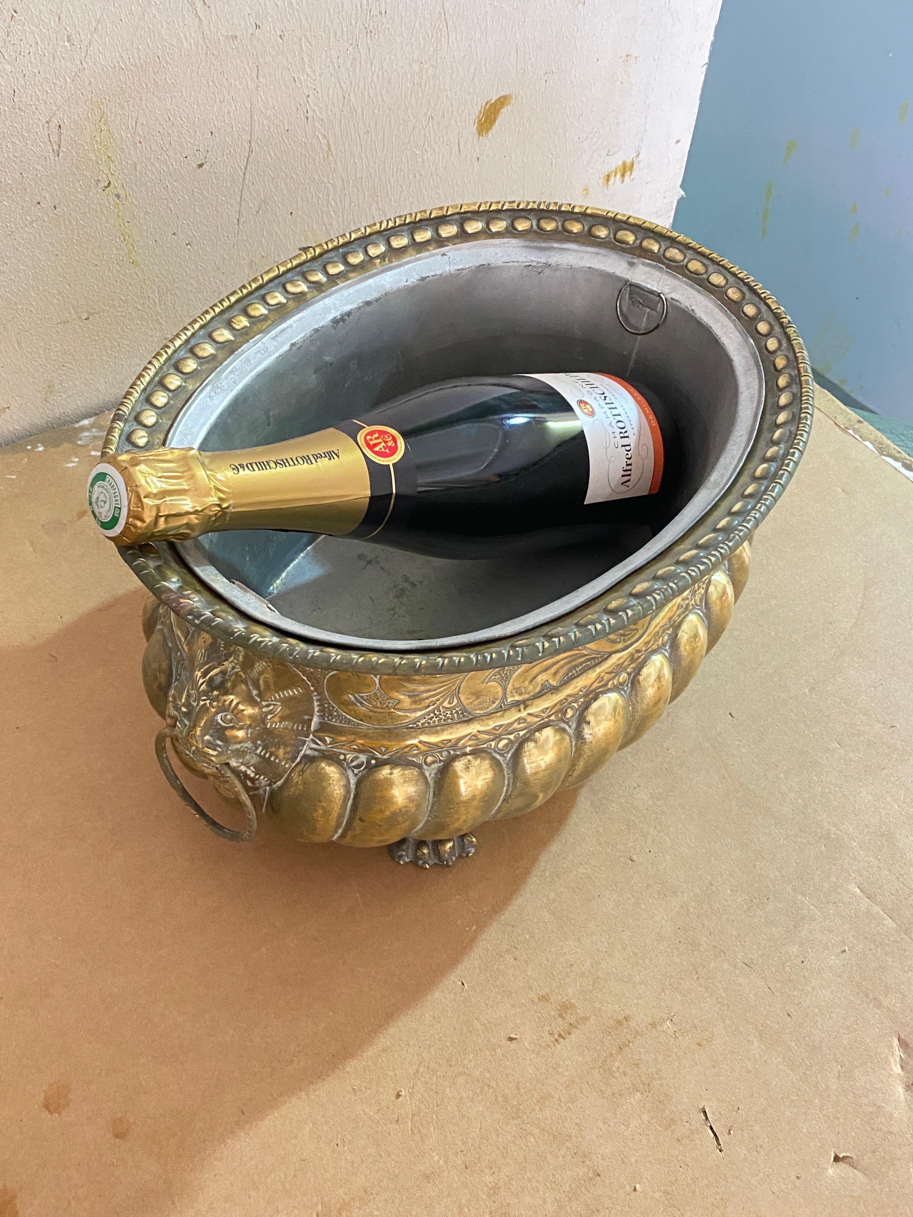 This planter is made of brass, made in France in the 19th century. It has ornaments in the shape of a lion, rings, and other figures. Its color is gold, and it rests on four lion paws. The pewter tray makes it very easy to turn it into a champagne