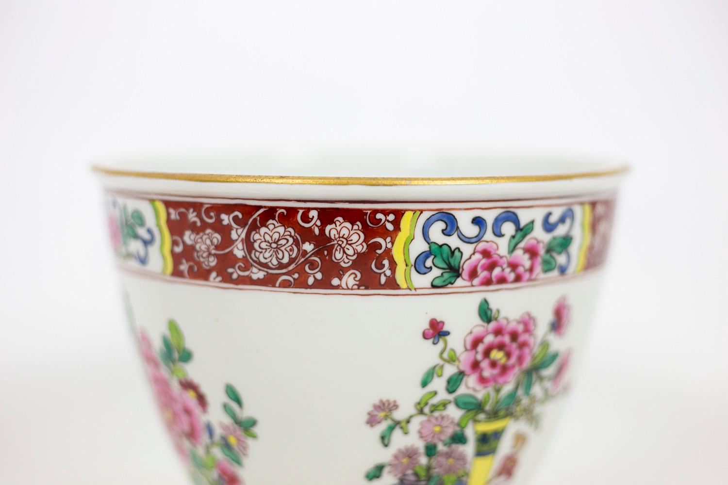 Planter in Samson porcelain. White background and vegetal decor in polychrome enamels representing chrysanthemums, peonies and cherry branches, cut or placed in vases. Red frieze with white vegetal scrolls and four cartouches framing flower motifs