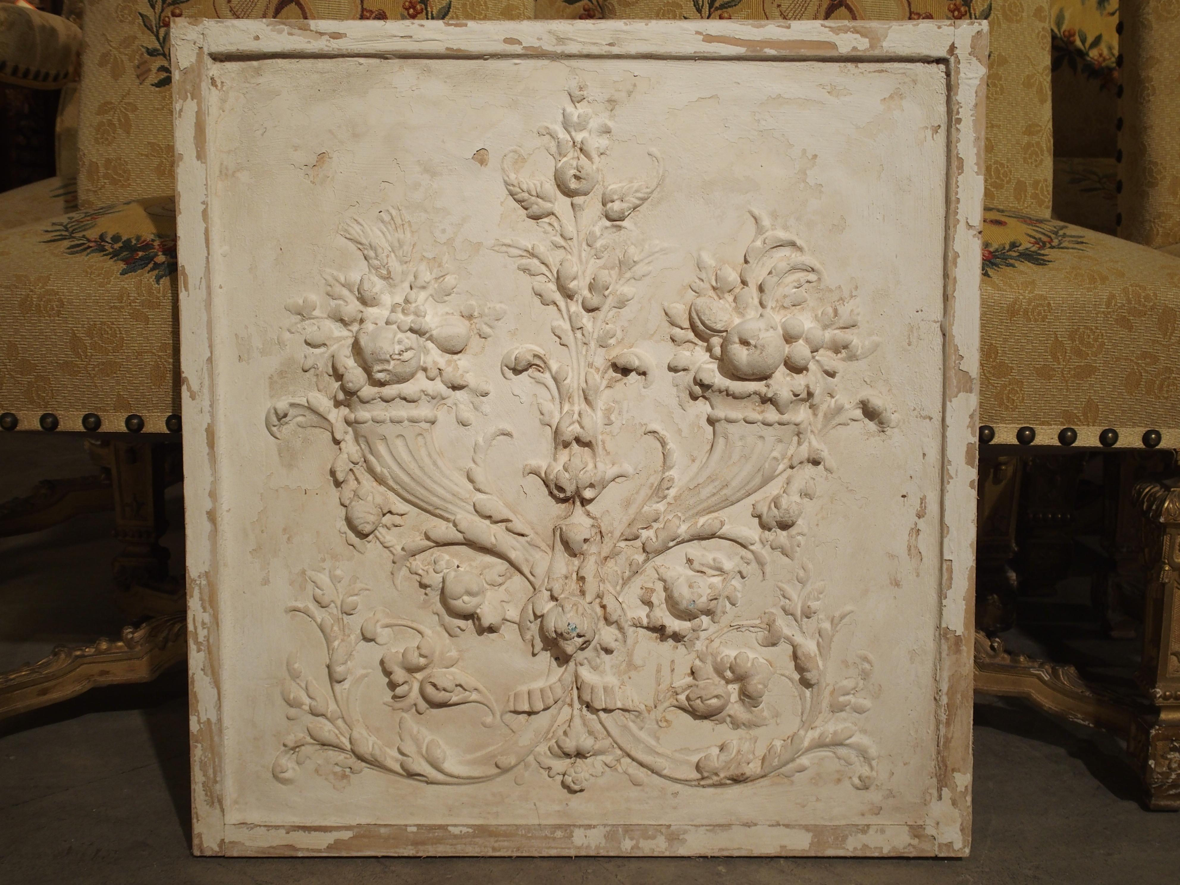 From France, this framed plaster bas relief panel depicts two cornucopias with scrolling rinceau at the center and sides. The cornucopias are filled with fruit, flowers and foliation. This wonderful panel was made with old wood elements and
