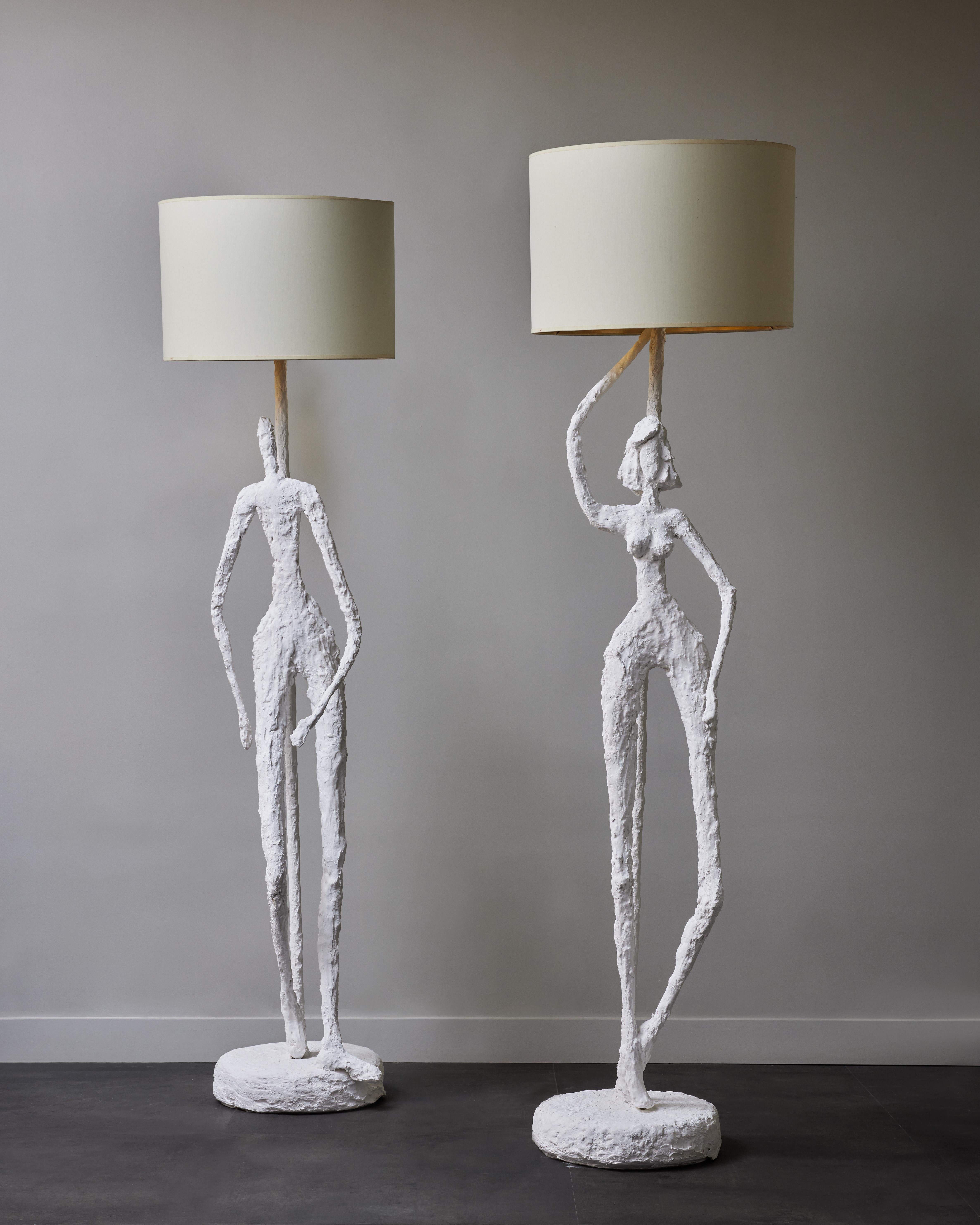 Pair of floor lamps made of a metal structure covered in plaster, and a single male and female character standing up.