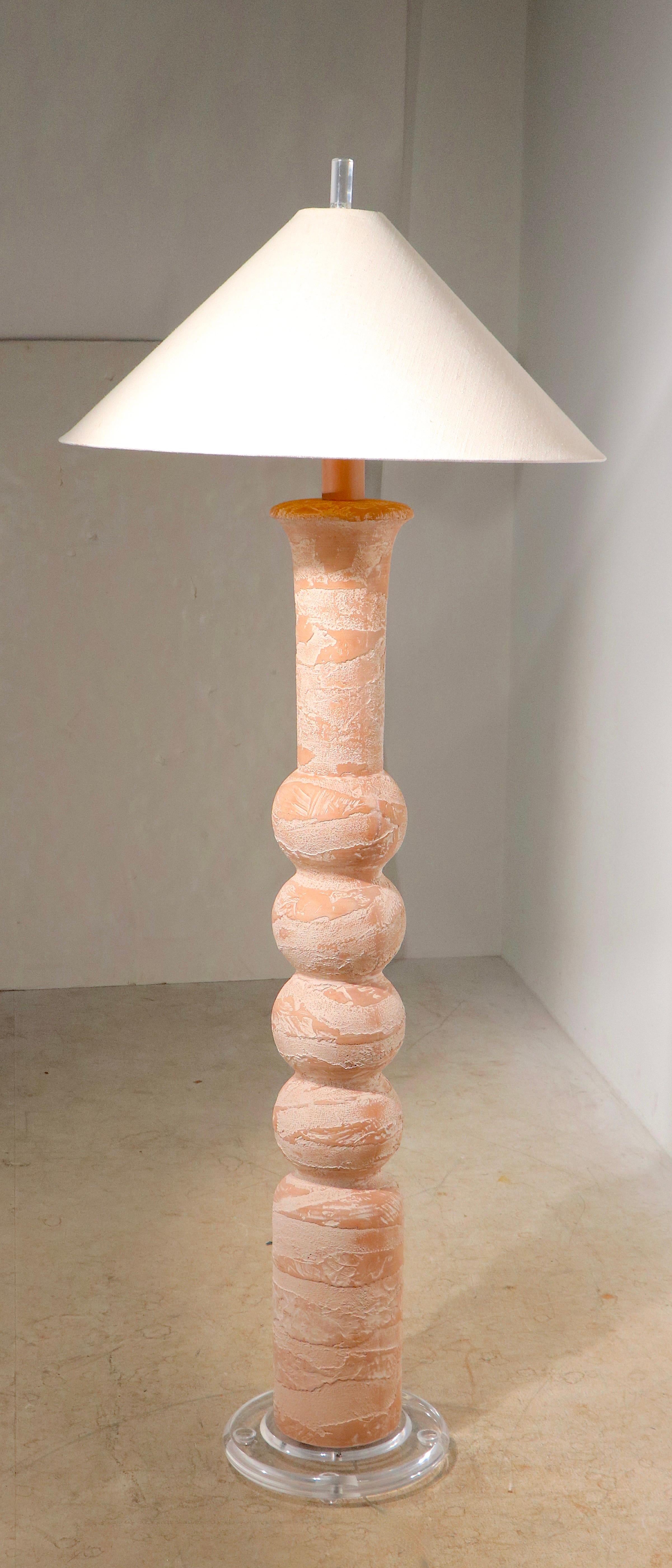 Classic Hollywood Regency Art Deco Revival Post Modern plaster lamp, with textured coral colored vertical center post, with a thick clear lucite base, lucite finial, and original cone form shade. Quintessential voguish 1980's chic style, exceptional