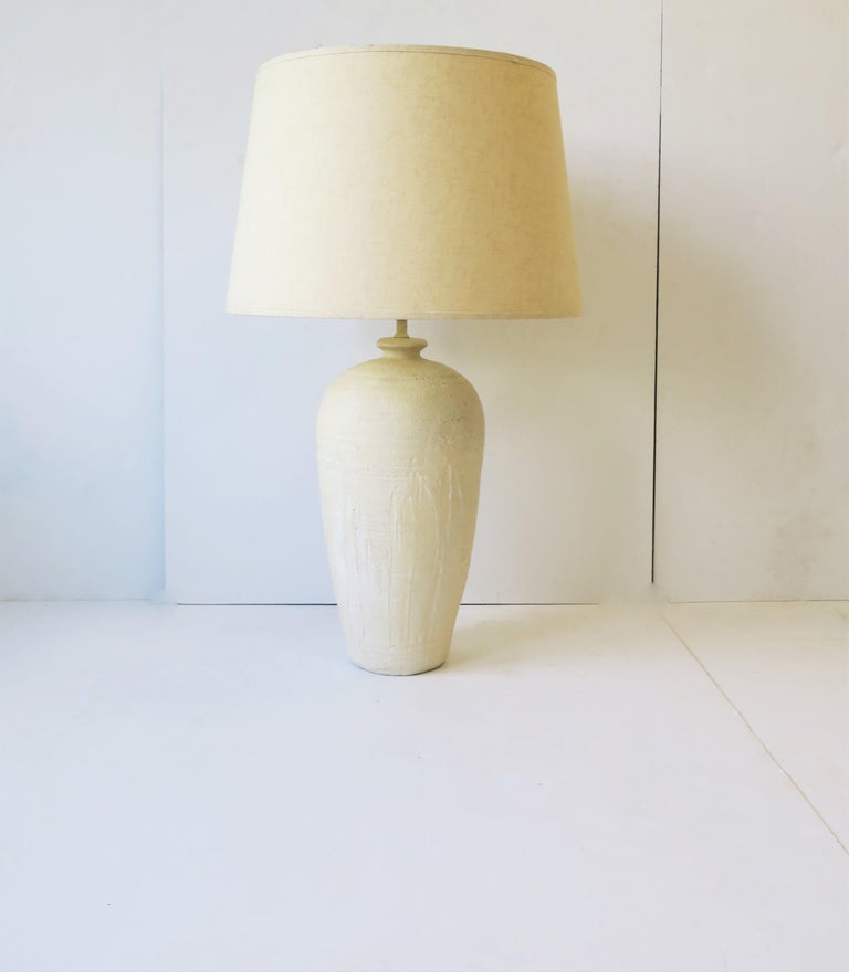 A beautiful white, off-white, cream, plaster pottery desk or table lamp with drip design matte texture and matching enamel neck, circa mid-20th century. 

Lamp measurements: 
32.75
