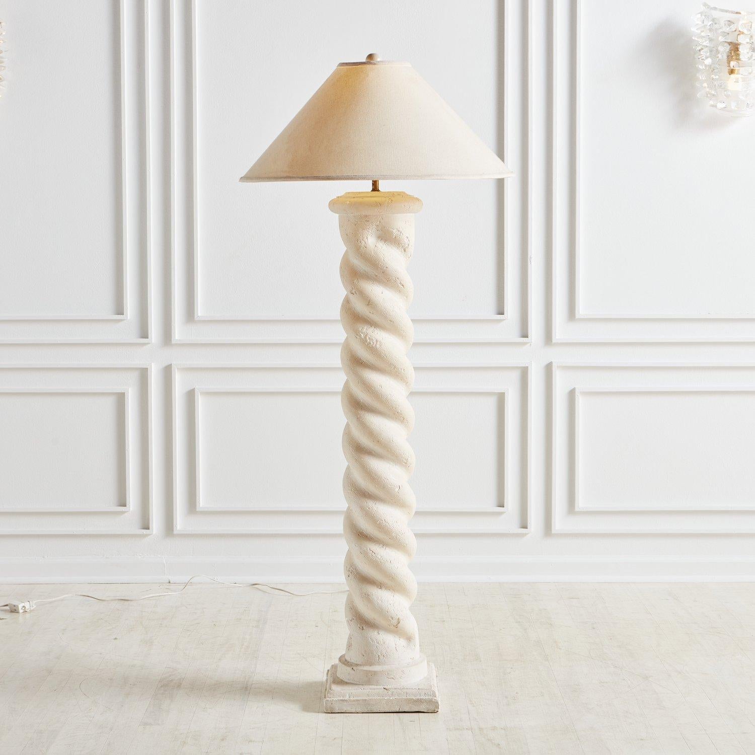 A plaster floor lamp in the style of Michael Taylor featuring a spiral column design with a square base. The textured plaster offers an organic elegance reminiscent of white-washed stone or unfilled travertine. USA, 1980s.