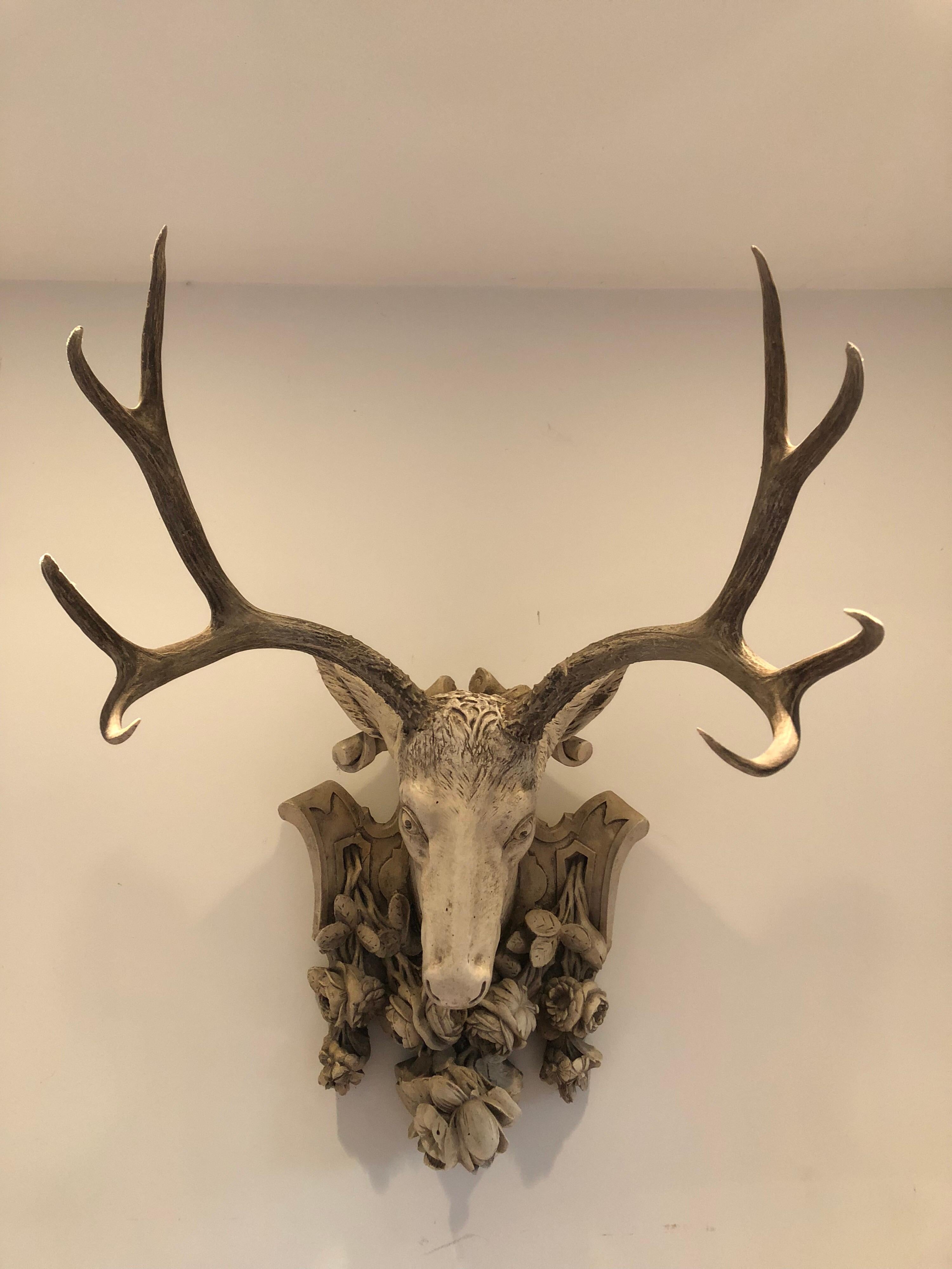 An interesting plaster stag mount adorned with floral motif crest.