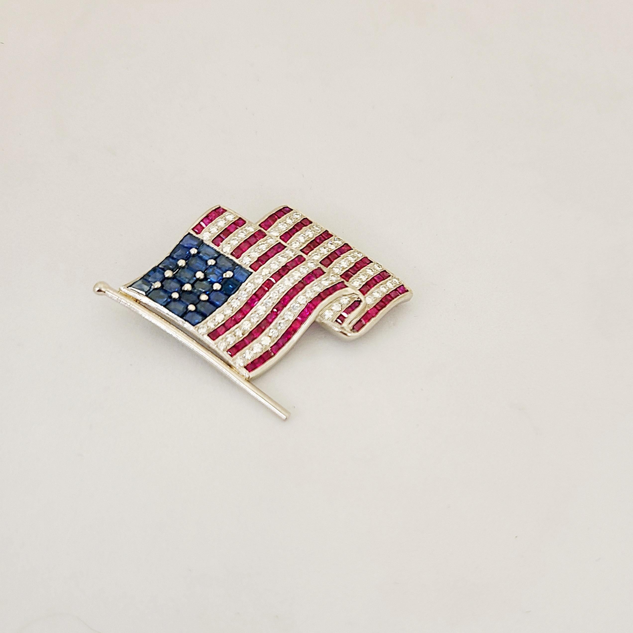 La broche parfaite pour 2020.
Notre broche drapeau américain est sertie de diamants ronds brillants et de rubis et saphirs taillés en carré. La broche mesure environ 1