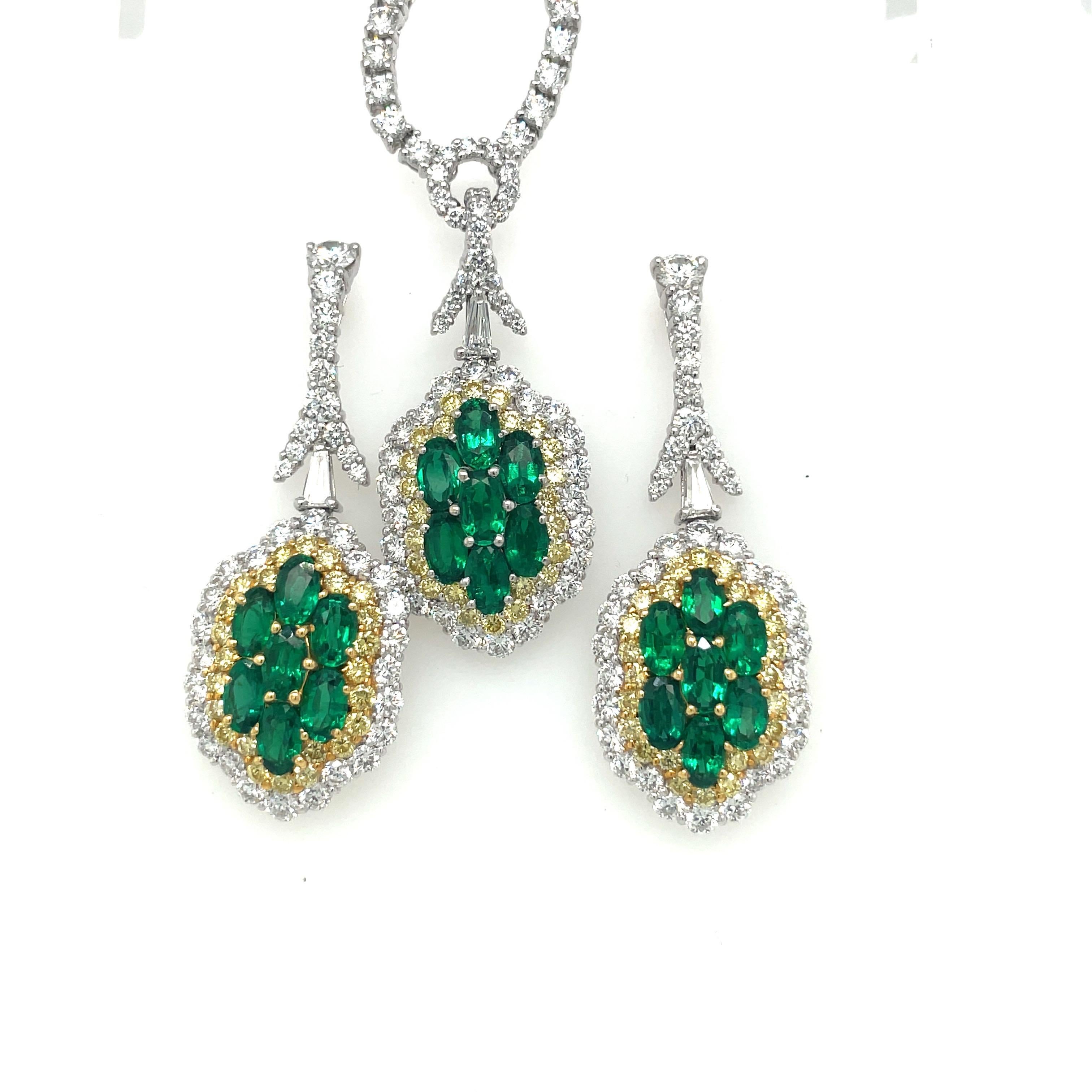 A magnificent diamond pendant necklace. Set in platinum, the necklace is designed with a single row of prong set round brilliant diamonds. A spectacular pendant is set with 7 oval emeralds. Natural yellow and white diamond surround the emeralds in a