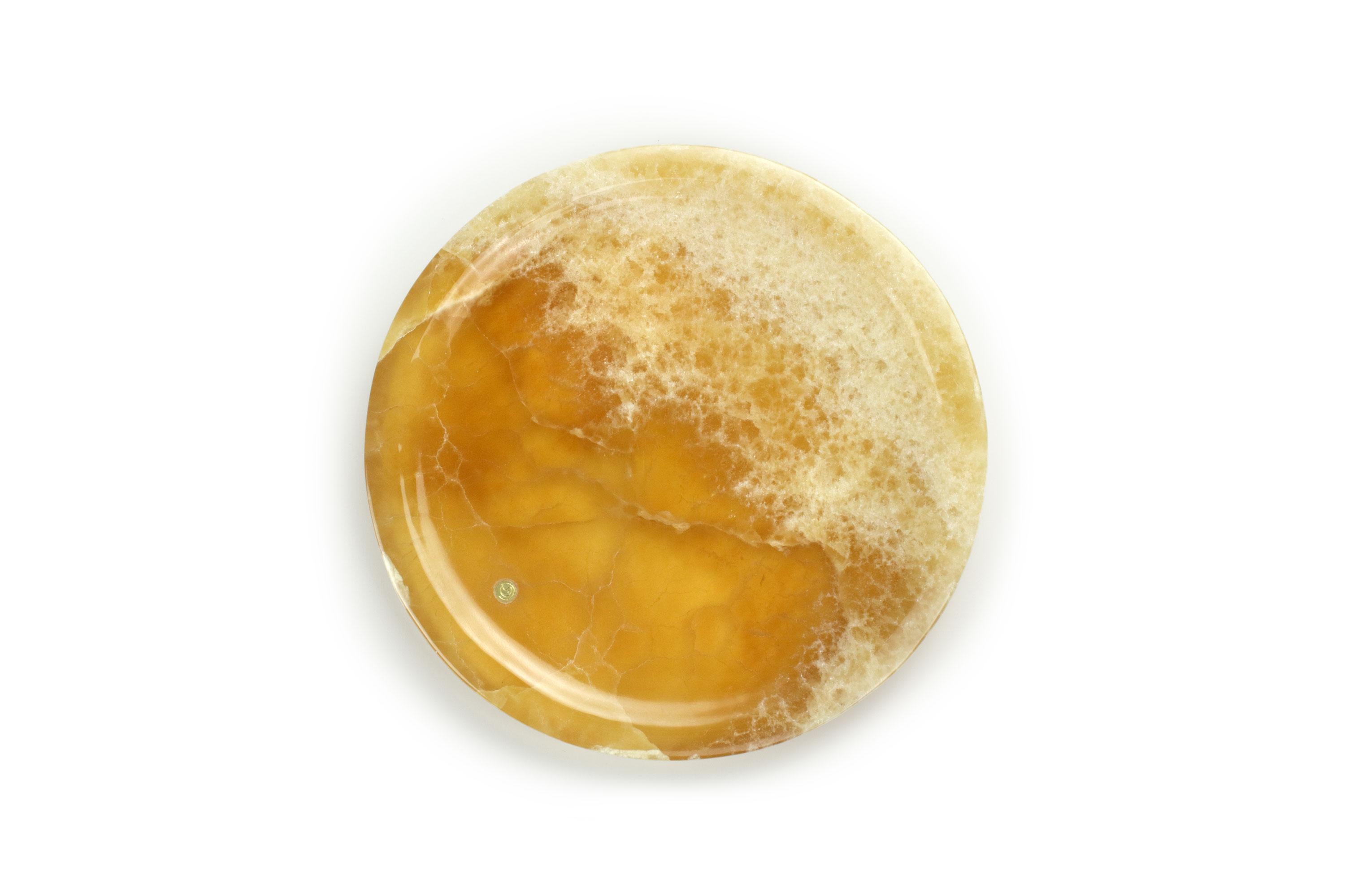 Assiette de présentation circulaire sculptée à la main en onyx ambré. La finition polie souligne la transparence de l'onyx, ce qui en fait un objet très précieux.
Utilisation multiple en tant qu'assiettes, plateaux et récipients. 

Dimensions : D 22
