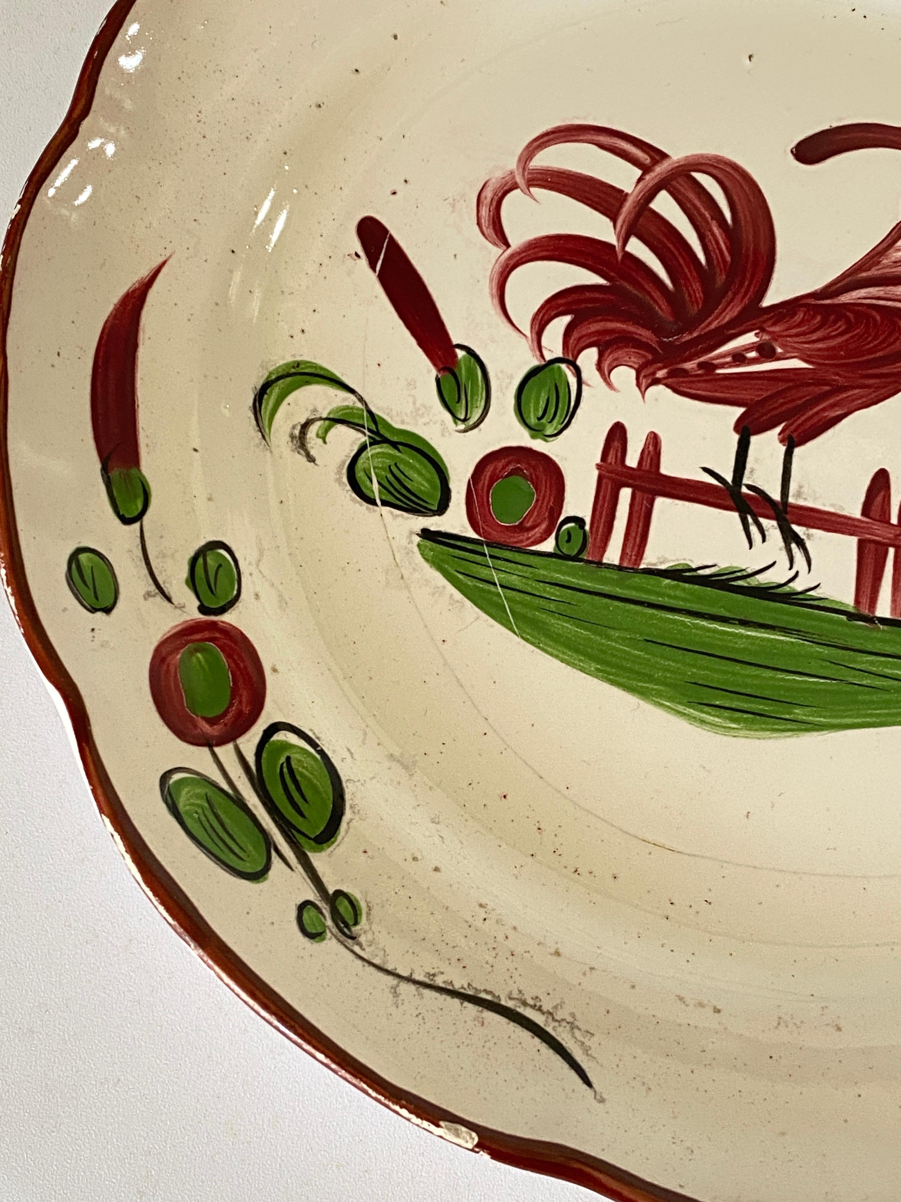 The plate is in faience. It has been made in France, during the 19th century.
The pattern decor is a rooster and the main colors green and red.