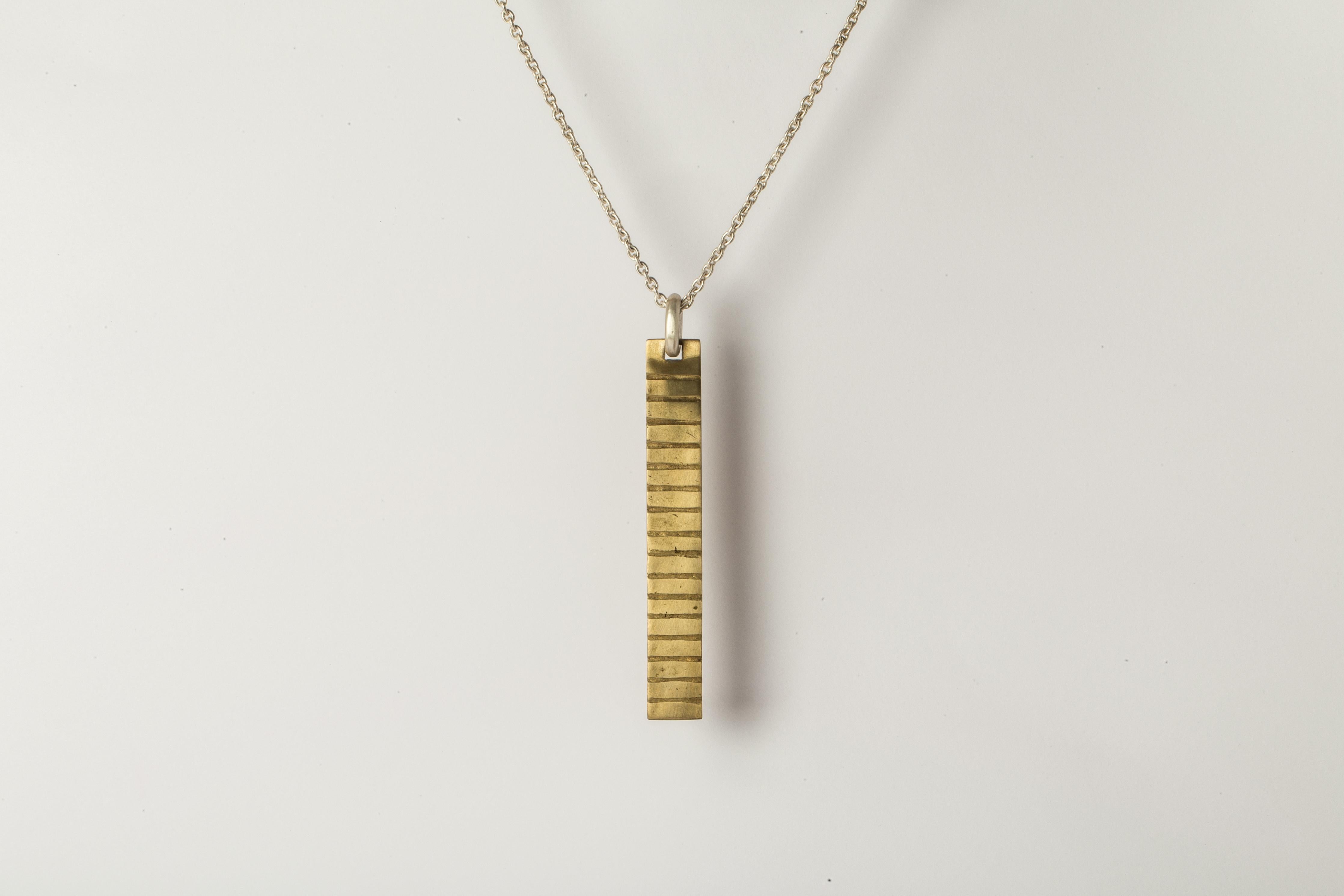 Plate necklace in brass, it comes on a 74cm sterling silver chain. The patterns or motifs on this piece are created using acid etching. An item is painted with a resistant material and the motif is scratched into the surface by hand. The entire