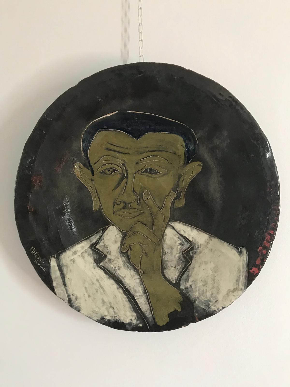 Self-portrait of Salvatore Meli painted on ceramic. 

Salvatore Meli was born in Comiso, in the province of Ragusa, in 1929 where he attended the local School of Art completing his training in Florence, first at the Art Institute of Porta Romana