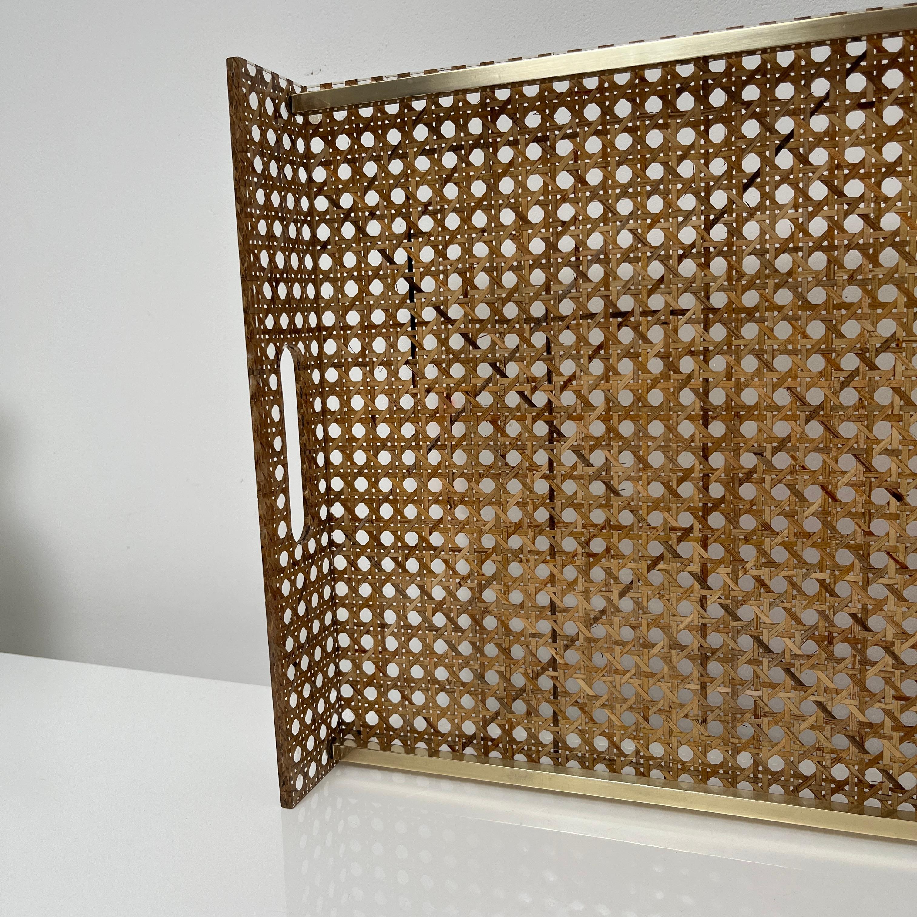Plateau de service  fait de lucite et de canne incrustée, rehaussée par un pourtour en laiton. Dans le  style des créations de  Christian Dior pour sa 