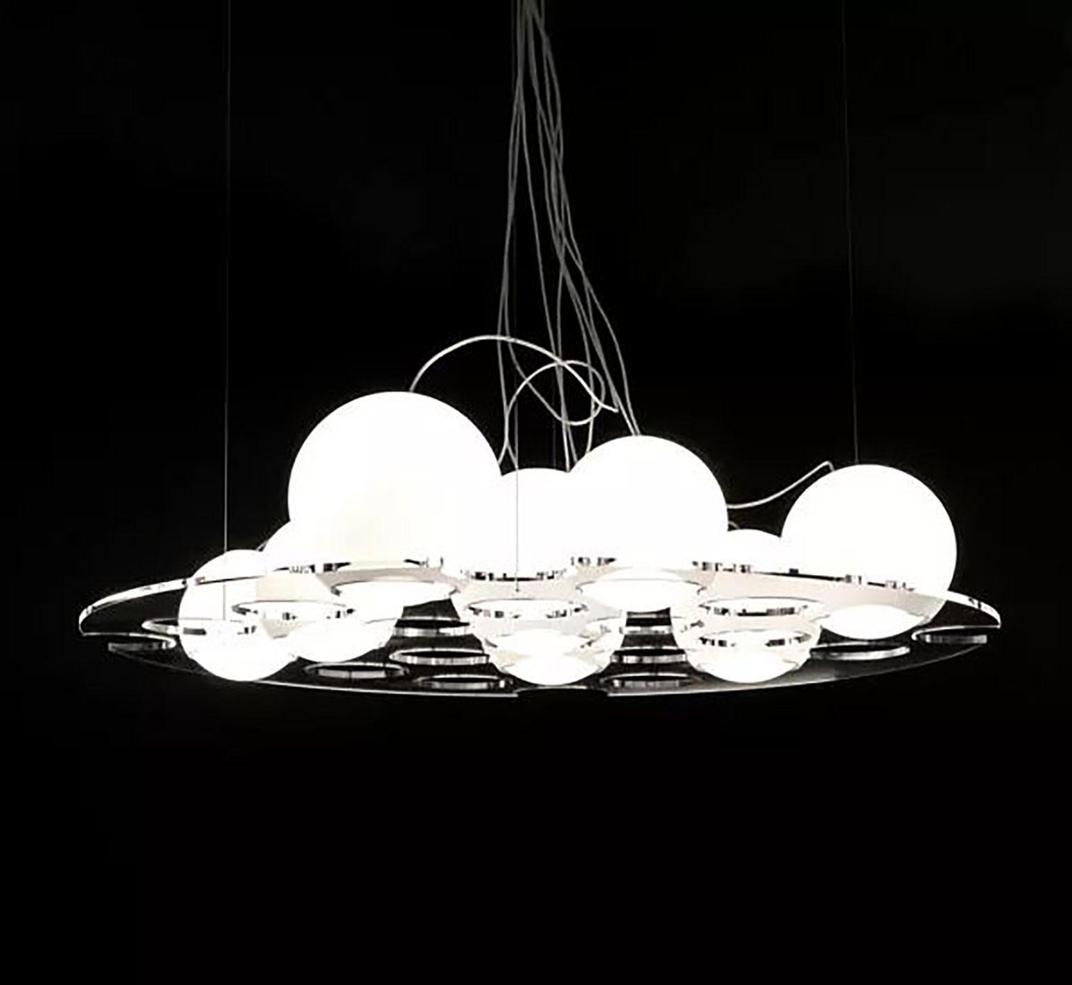 The plateau suspension lamp by Antonia Astori & Nicola De Ponti for Oluce. This truly unique and customizable lamp uses a plateau in transparent laser-finished and polished PMMA with a variety of holes that allow you to position the multiple glass
