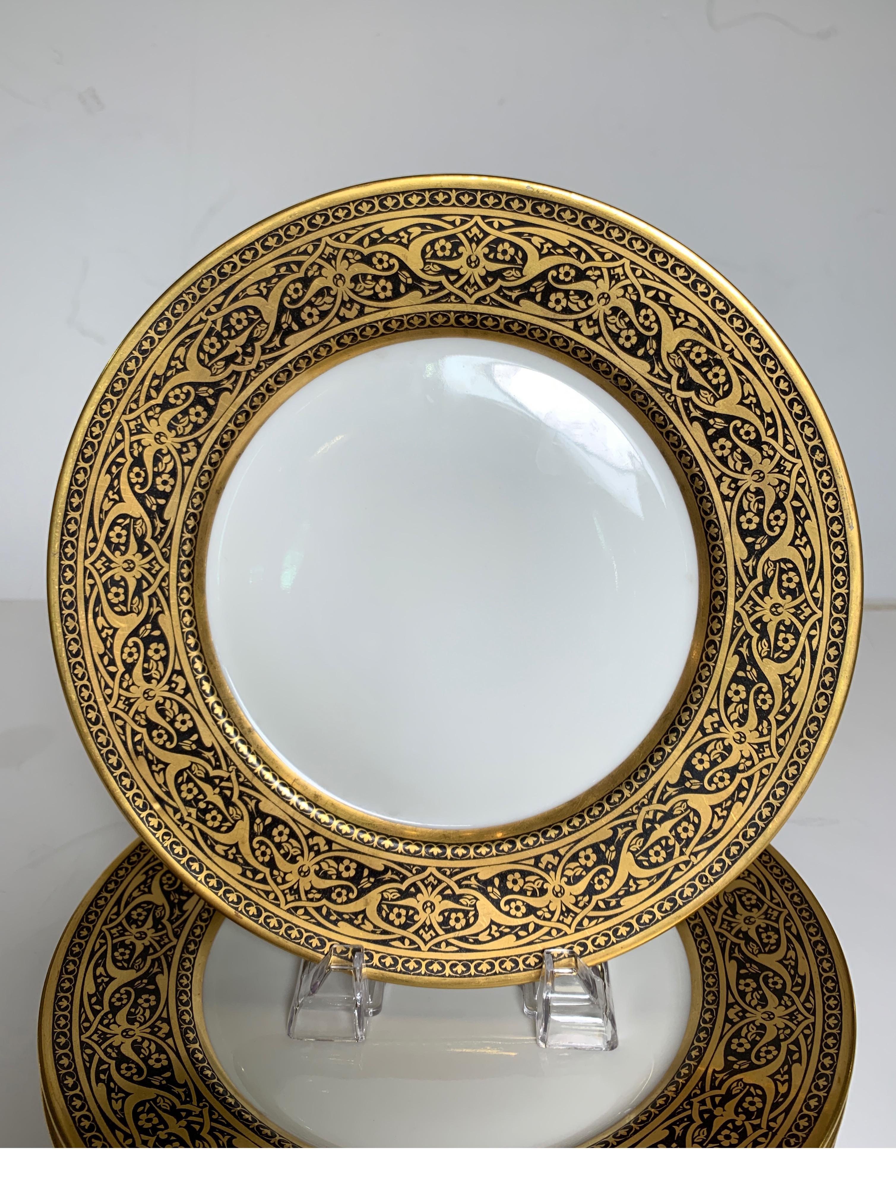 A set of 6 French black and gold service dinner plates with elaborate borders. The white porcelain with an exotic persinan style border marked Limoges France Superieur. 10.5