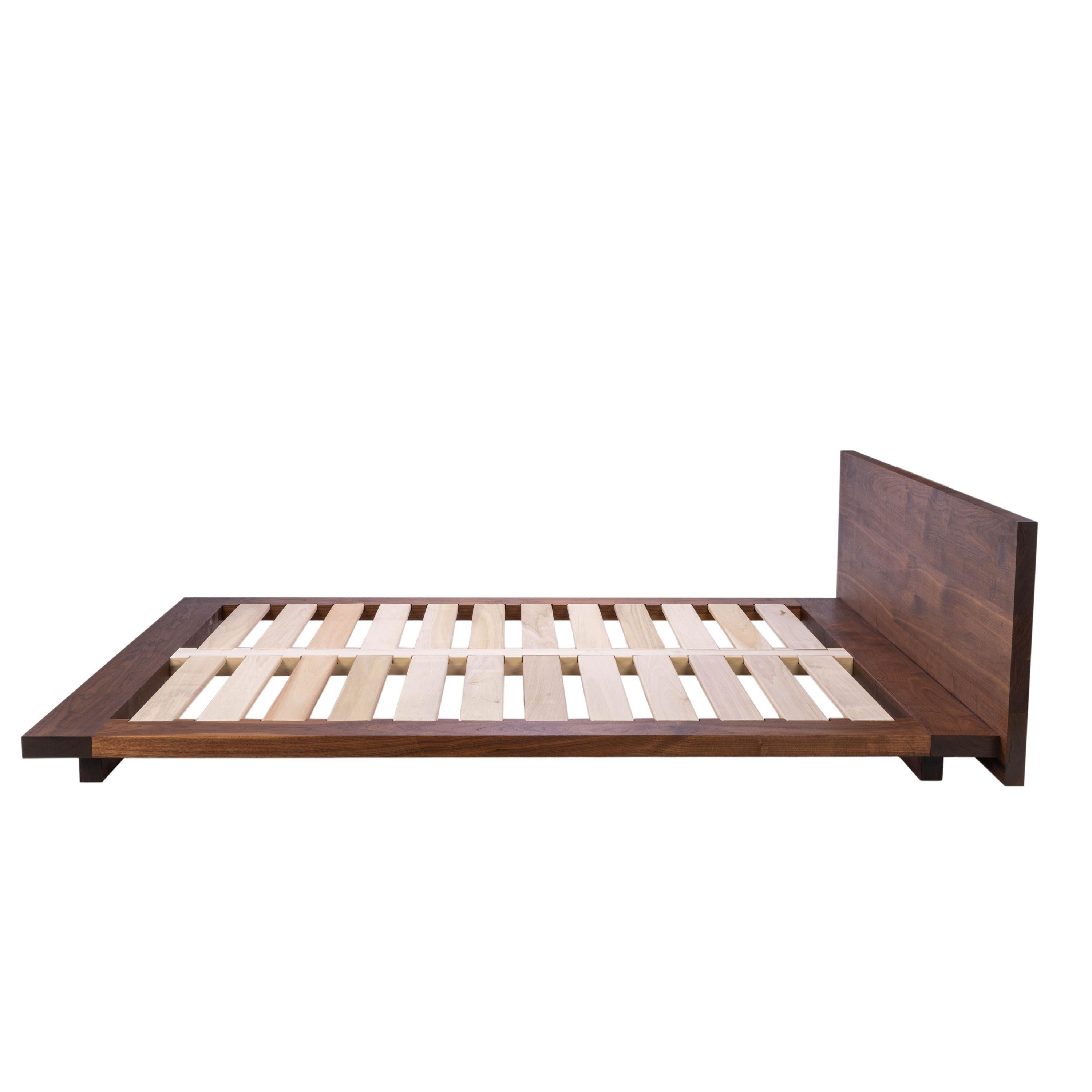 Le lit plate-forme n° 3 est un lit plate-forme bas et large en bois massif, l'ultime base de luxe pour votre matelas. Dans ce modèle, le lourd cadre de lit en bois massif et la tête de lit semblent visuellement flotter au-dessus de votre sol.   Des