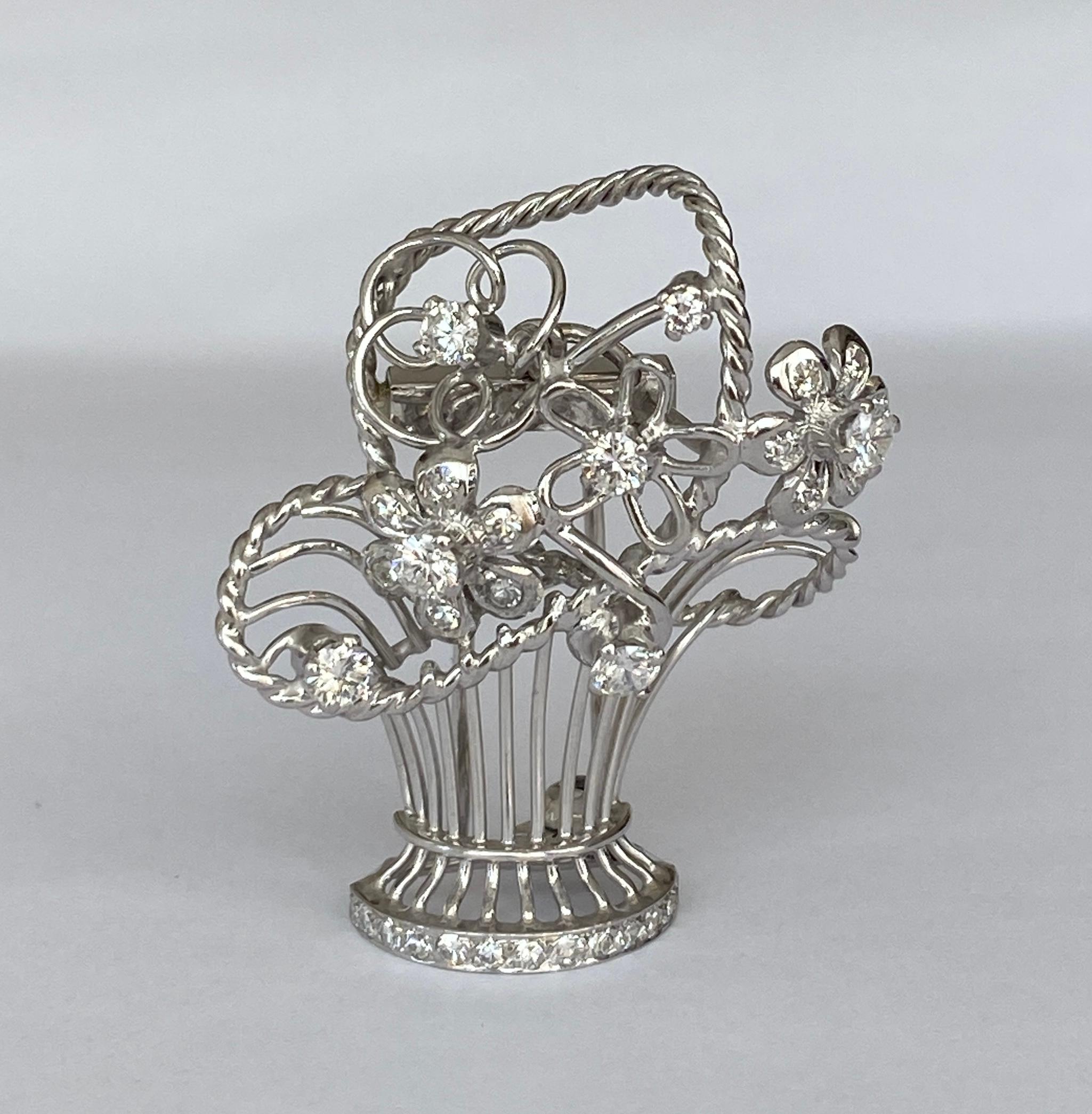 Later Art Deco Brooch/ pendant made of 14 kt white  gold and platina set. The brooch is made like a basket of flowers set with 24 stuks  octagon cut diamonds approx. 0.30 ct H/VS/SI and 7 stuks brilliant cut diamonds approx. 0.50 ct of quality