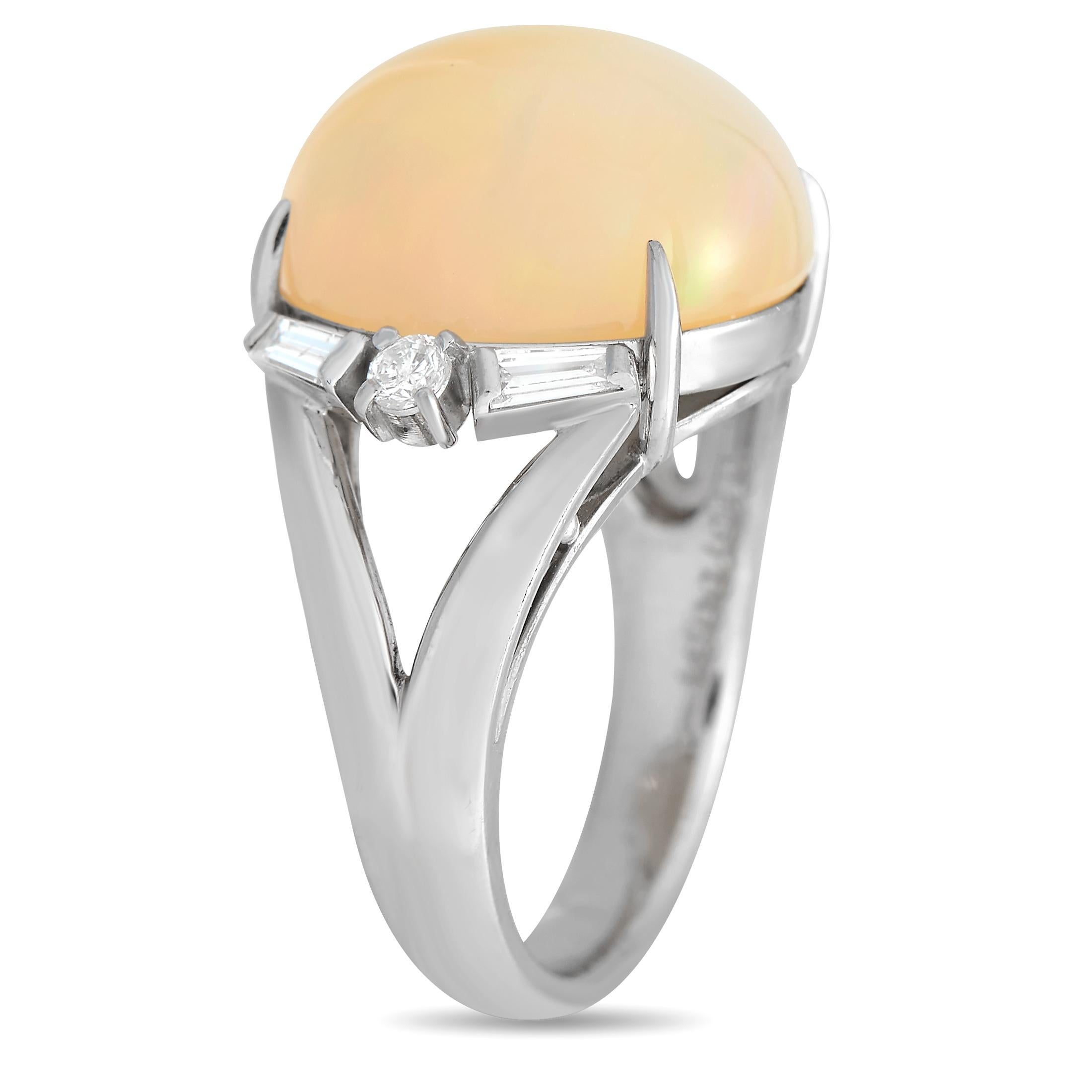 A bold 9.87 carat Opal with a stunning peach hue makes a statement at the center of this rings simple Platinum setting. Accented by Diamonds totaling 0.34 carats, it features a 4mm wide band and a top height measuring 10mm.This jewelry piece is