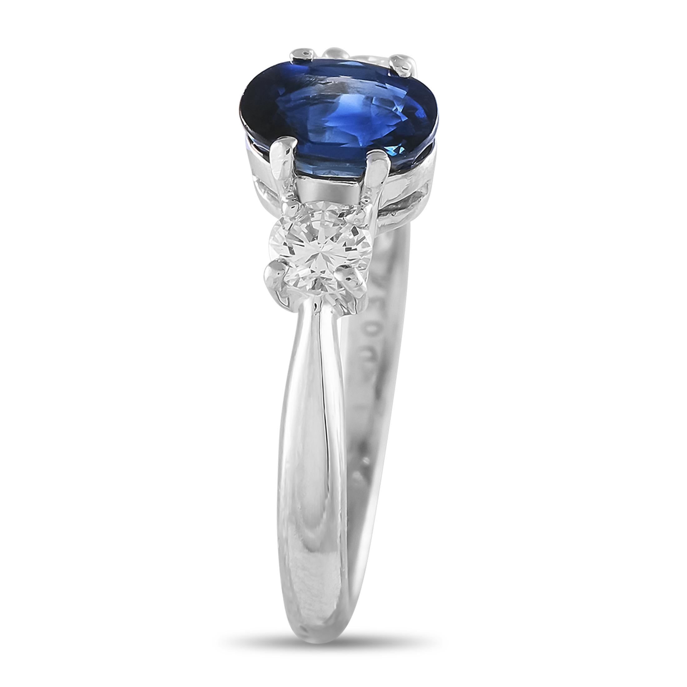 A deep royal blue sapphire in oval cut is flanked by round diamonds. The three stones sit on a pinched band made from enduring platinum. This ring of lasting beauty and resilience is poised to become a cherished heirloom.This Platinum 0.37 ct