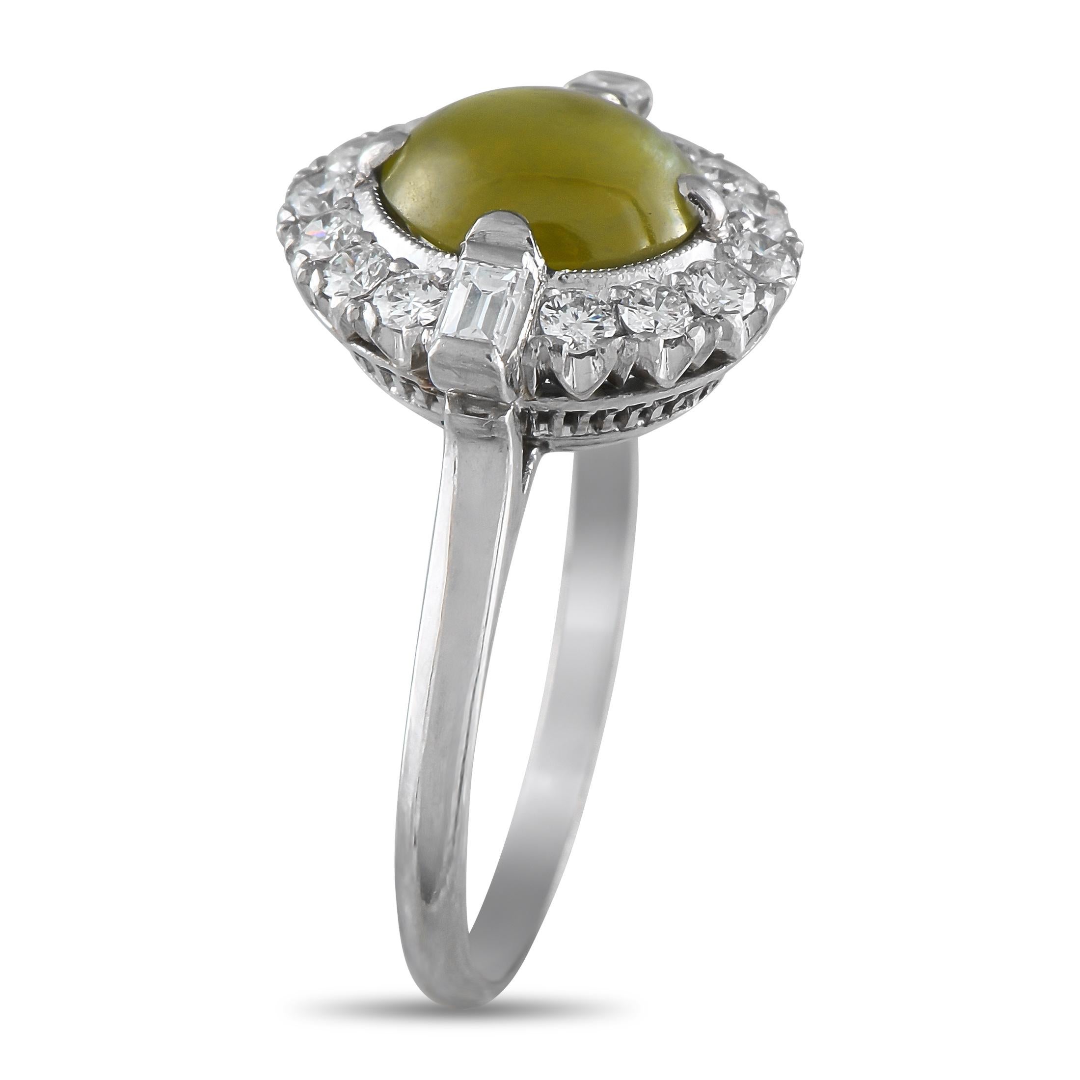 Questo anello di lusso è di un'eleganza unica. Una luminosa pietra centrale a occhio di gatto da 1,10 carati rende questo pezzo immediatamente accattivante, mentre una scintillante aureola di diamanti per un totale di 0,45 carati fornisce la