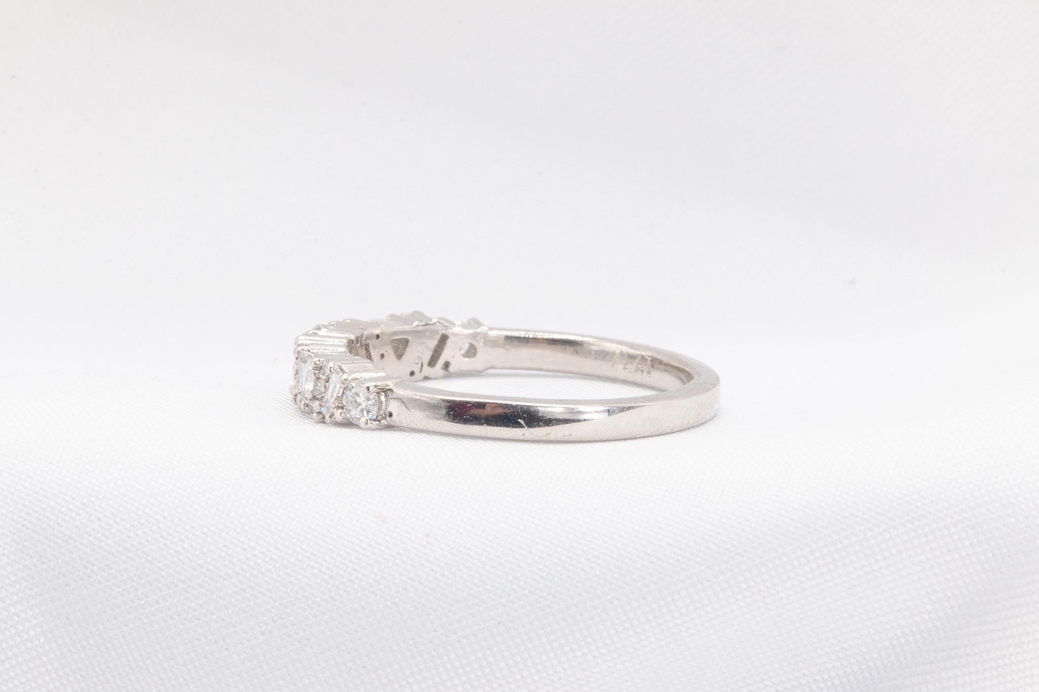 This elegant platinum band features approximately 0.54 carats of diamonds in a stunning mix of round, emerald, and trillion cuts, all graded F-G in color and VS1 in clarity, creating a refined touch of brilliance. Weighing 5.3 grams, this timeless