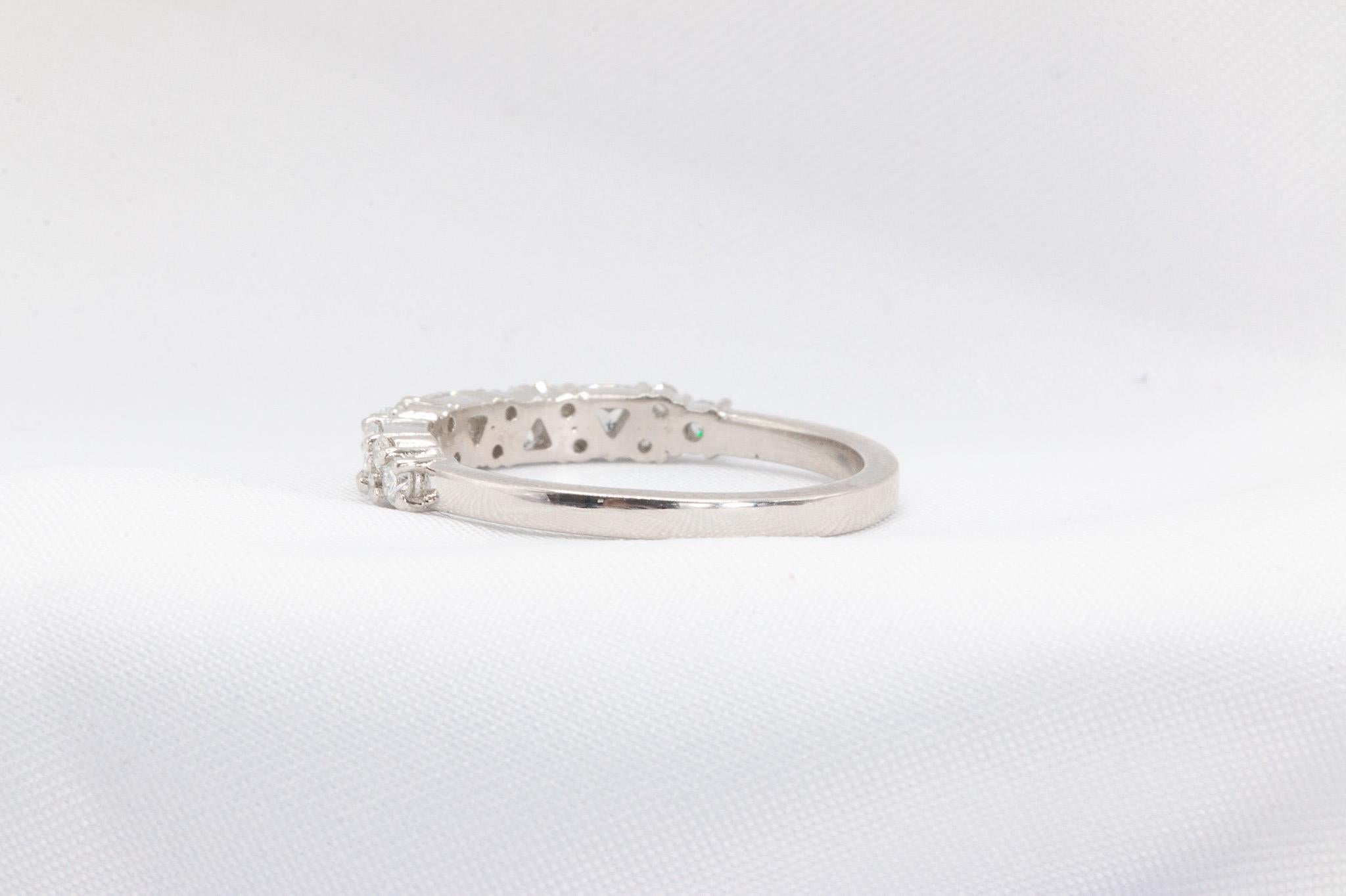 This elegant platinum band features approximately 0.58 carats of diamonds in a stunning mix of round and trillion cuts, all graded F-G in color and VS1 in clarity, creating a refined touch of brilliance. Weighing 4.8 grams, this timeless design is