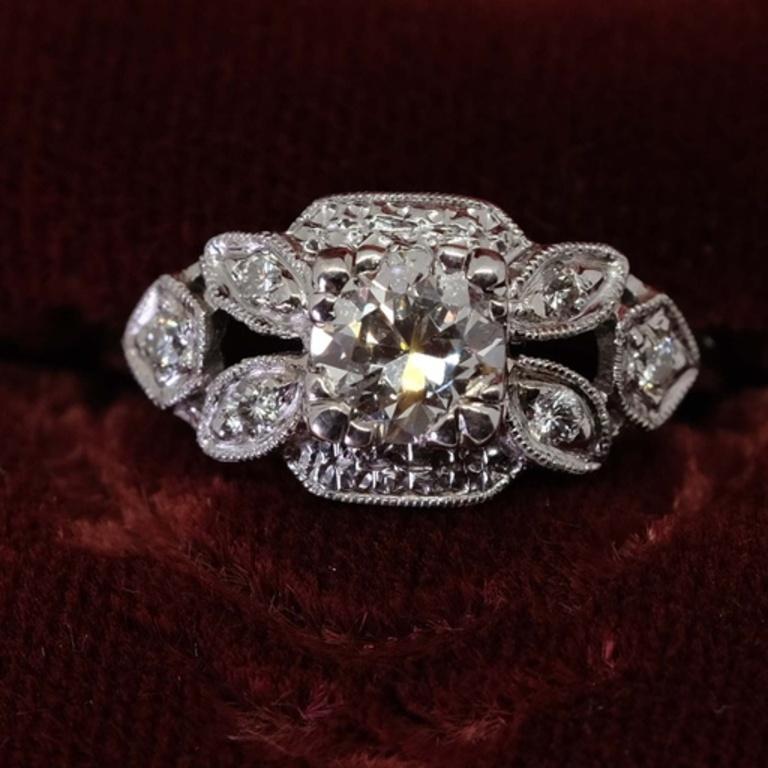 One-ladies Platinum ring with central round brilliant cut diamond in prong setting. Each shoulder is decorated with smaller diamonds. Estimated brilliant weight of 0.58 ct. Ring size 6
