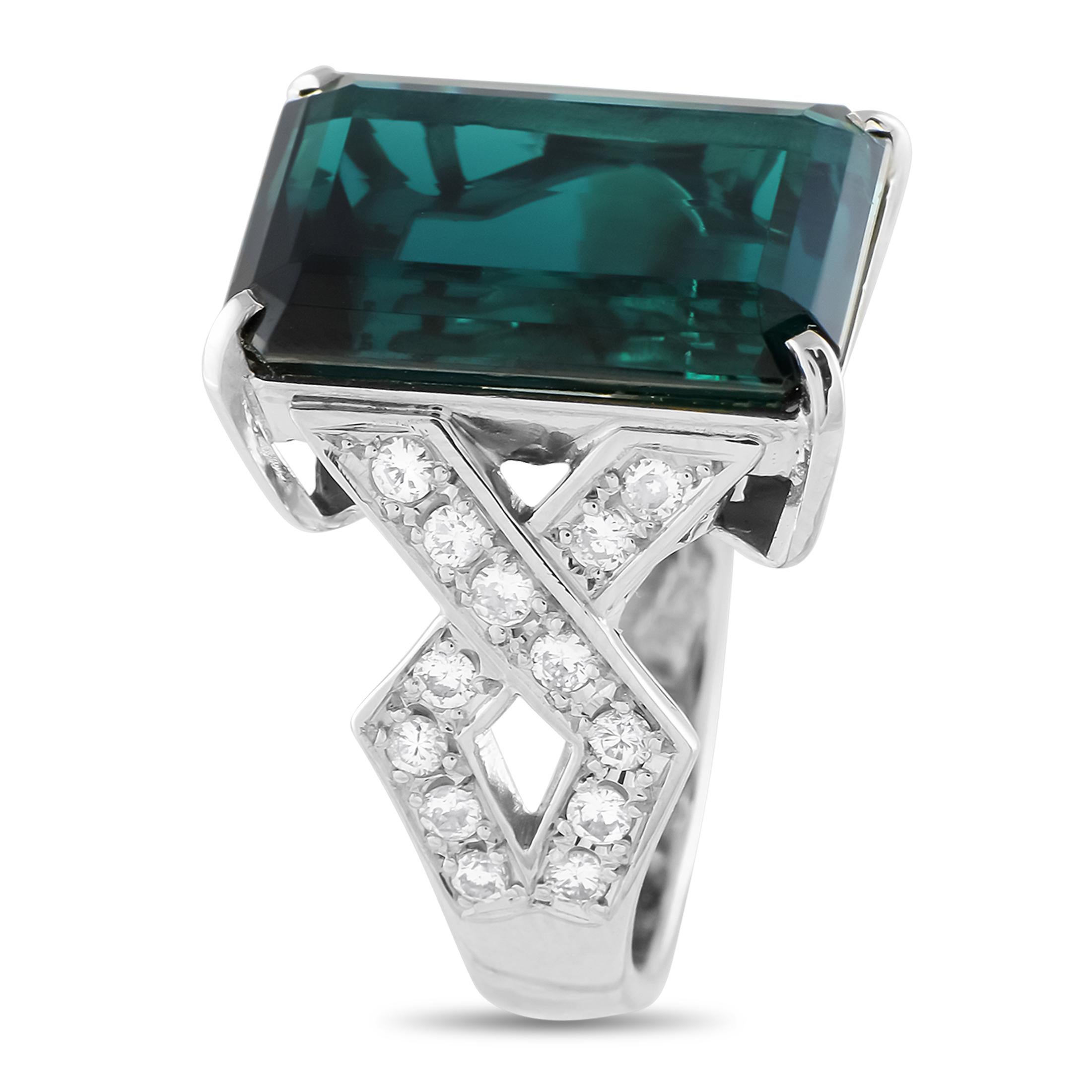 This is an platinum ring depicting old-world glamour. The band features angular, criss-cross shoulders lined with petite round diamonds. These lead to a majestic 14.72-carat tourmaline with a deep greenish-blue hue.This Platinum 0.60 ct Diamond and