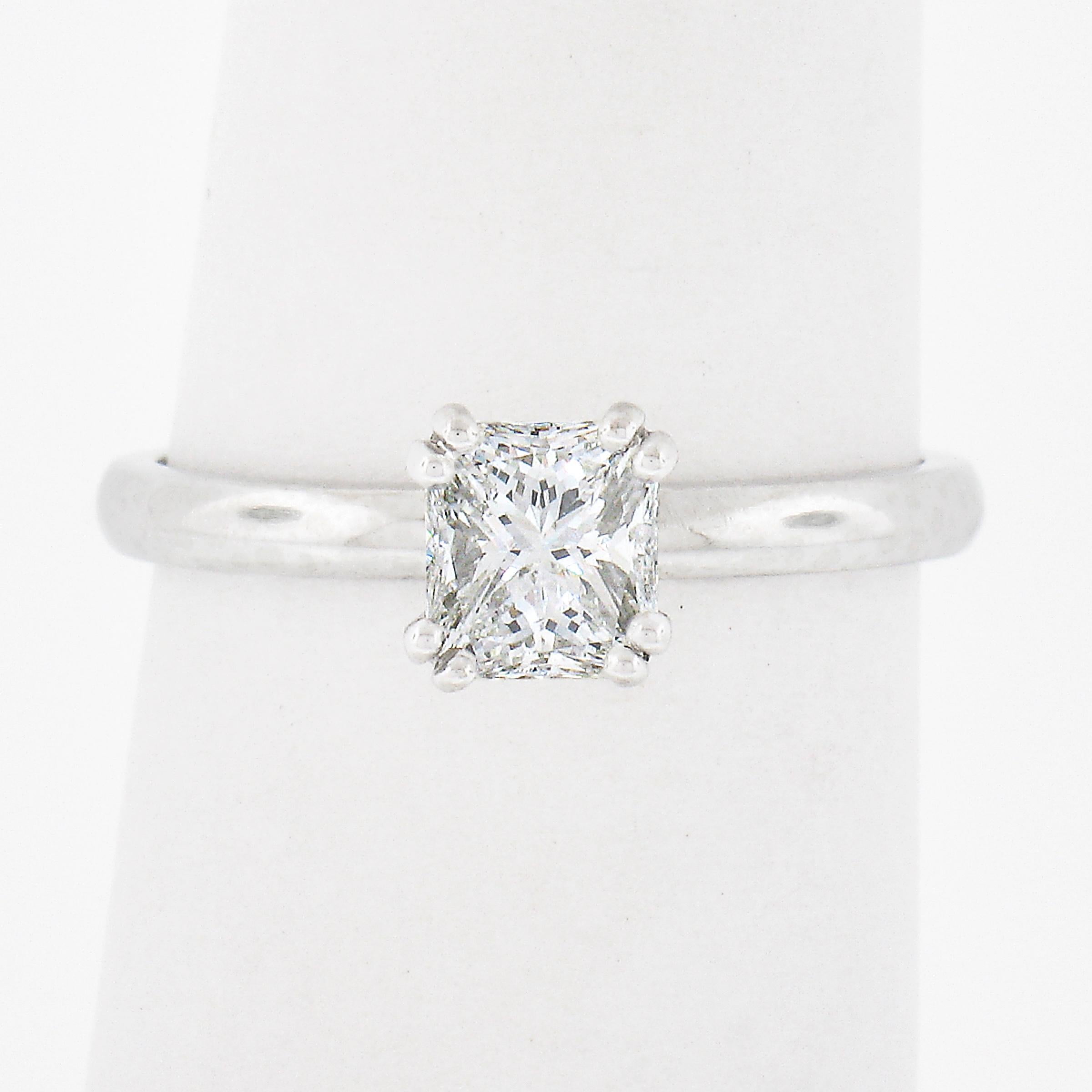 This classic and simply gorgeous solitaire engagement ring is crafted in solid platinum and features a very fine quality emerald cut diamond neatly set at its center. This petite, GIA certified, solitaire weighs exactly 0.68 carats and displays