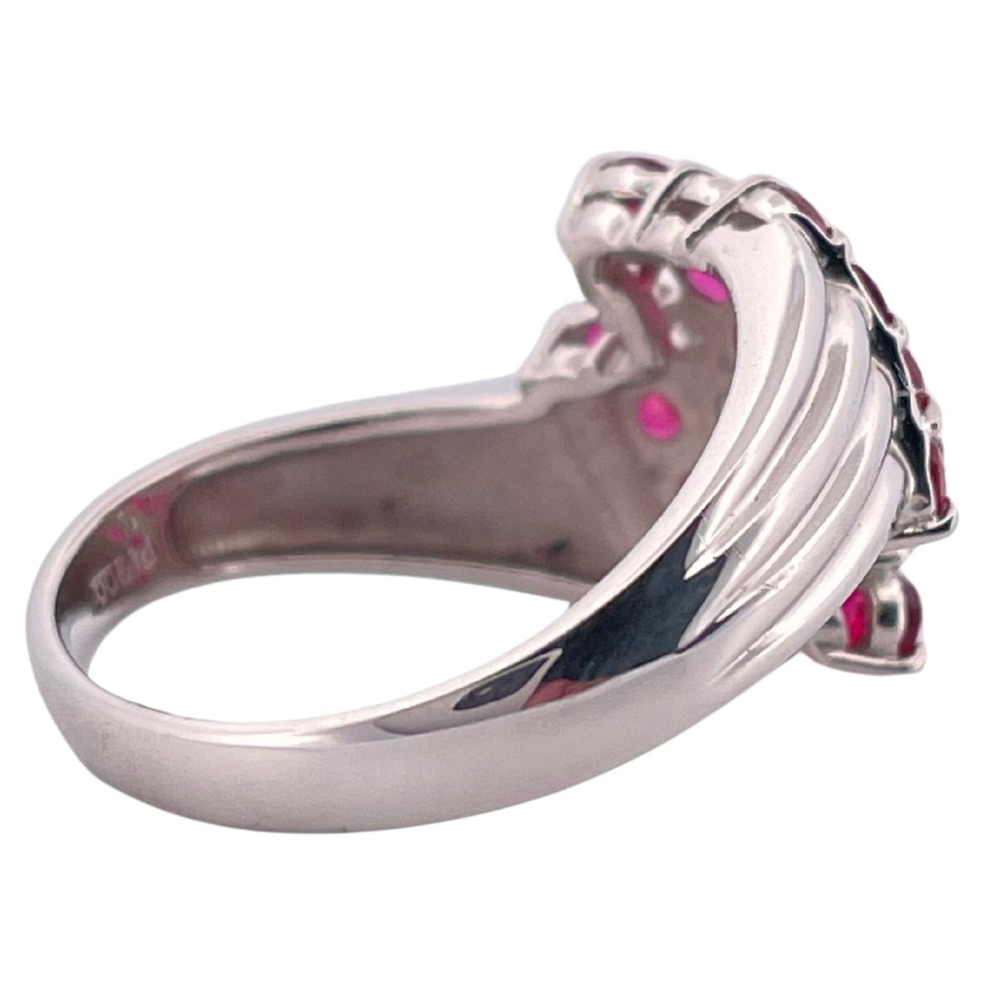 Questo sorprendente anello in platino mette in mostra una vibrante miscela di rubini e diamanti in un audace design geometrico. Realizzato in platino con marcatura Pt900, il pezzo presenta circa 0,75 carati di peso totale di rubini a taglio rotondo,
