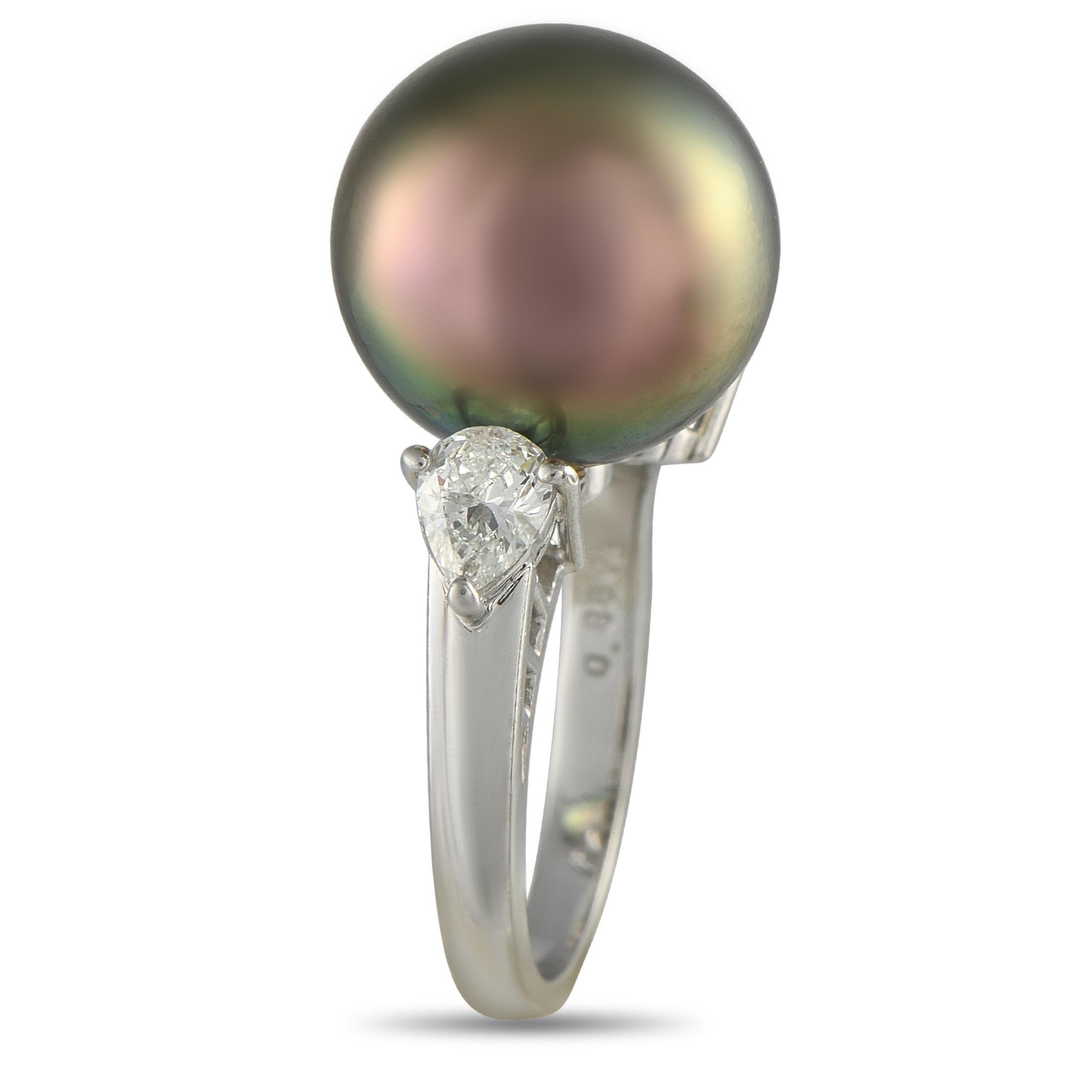 Lujo en estado puro. Una perla negra de 14,2 mm de magnífica iridiscencia descansa con gracia en un elegante y duradero engaste de platino. El lustroso brillo natural de la perla se ve realzado por el resplandor de los diamantes talla pera y talla