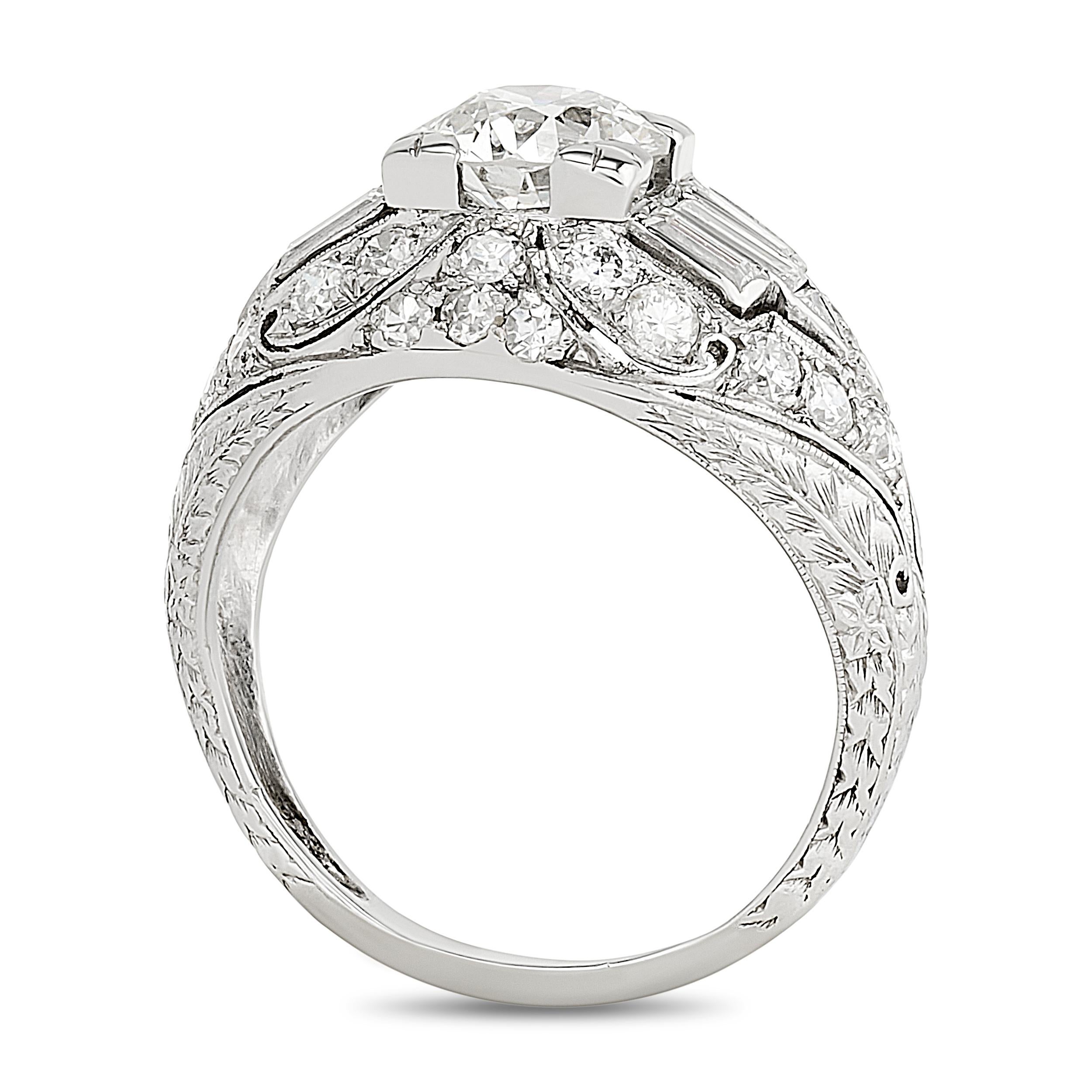 Dieser Platinring zeigt einen zentralen Diamanten im alten europäischen Schliff in einer quadratischen, geometrischen Fassung, die mit Baguette- und runden Diamanten in einer detaillierten, durchbrochenen und gekörnten Fassung verziert ist.

Center
