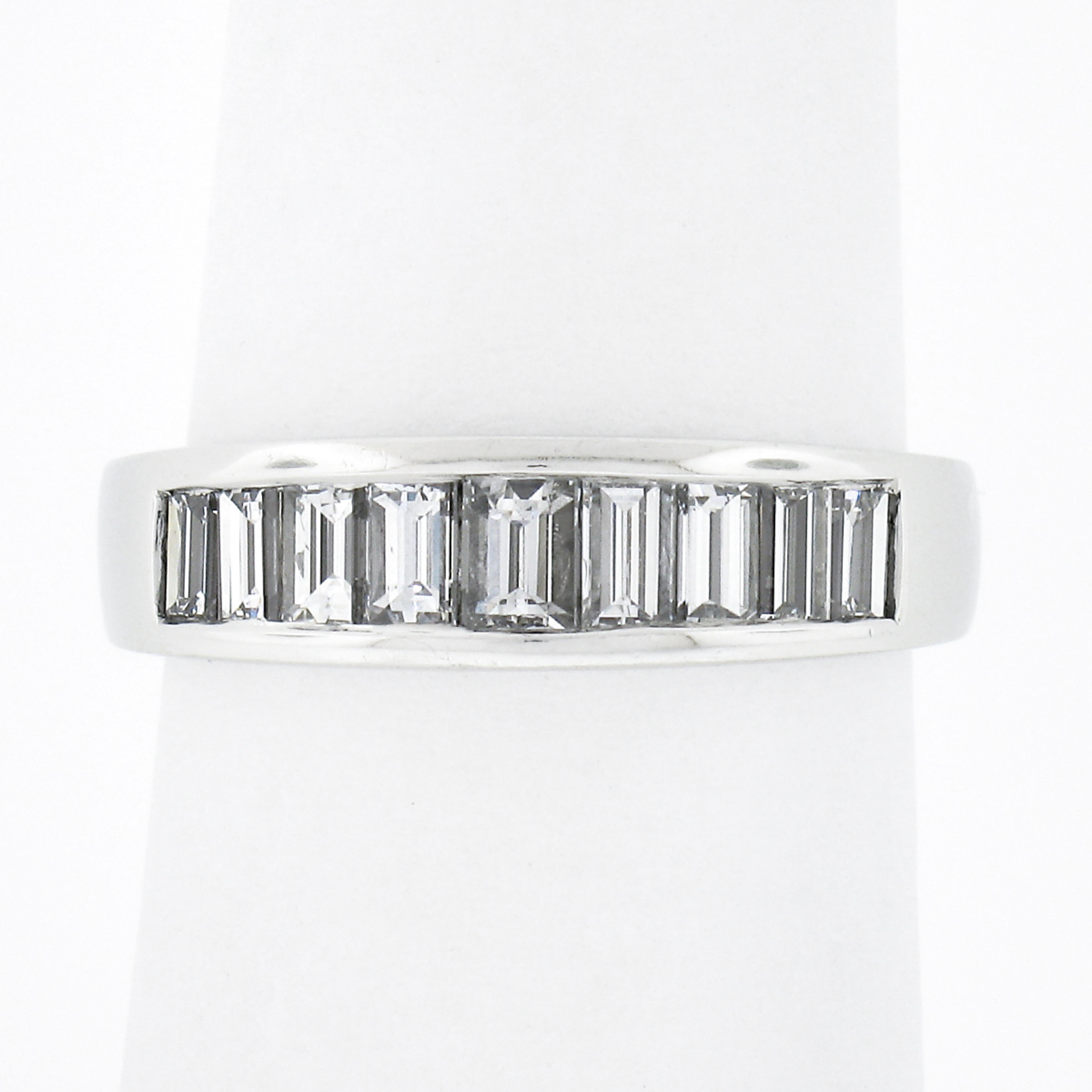 This stunning band ring is crafted in solid platinum and features 9 straight baguette cut diamonds neatly channel set across its top. The diamonds total exactly 1.02 carats and are incredibly brilliant with spectacular amount sparkle and shine that