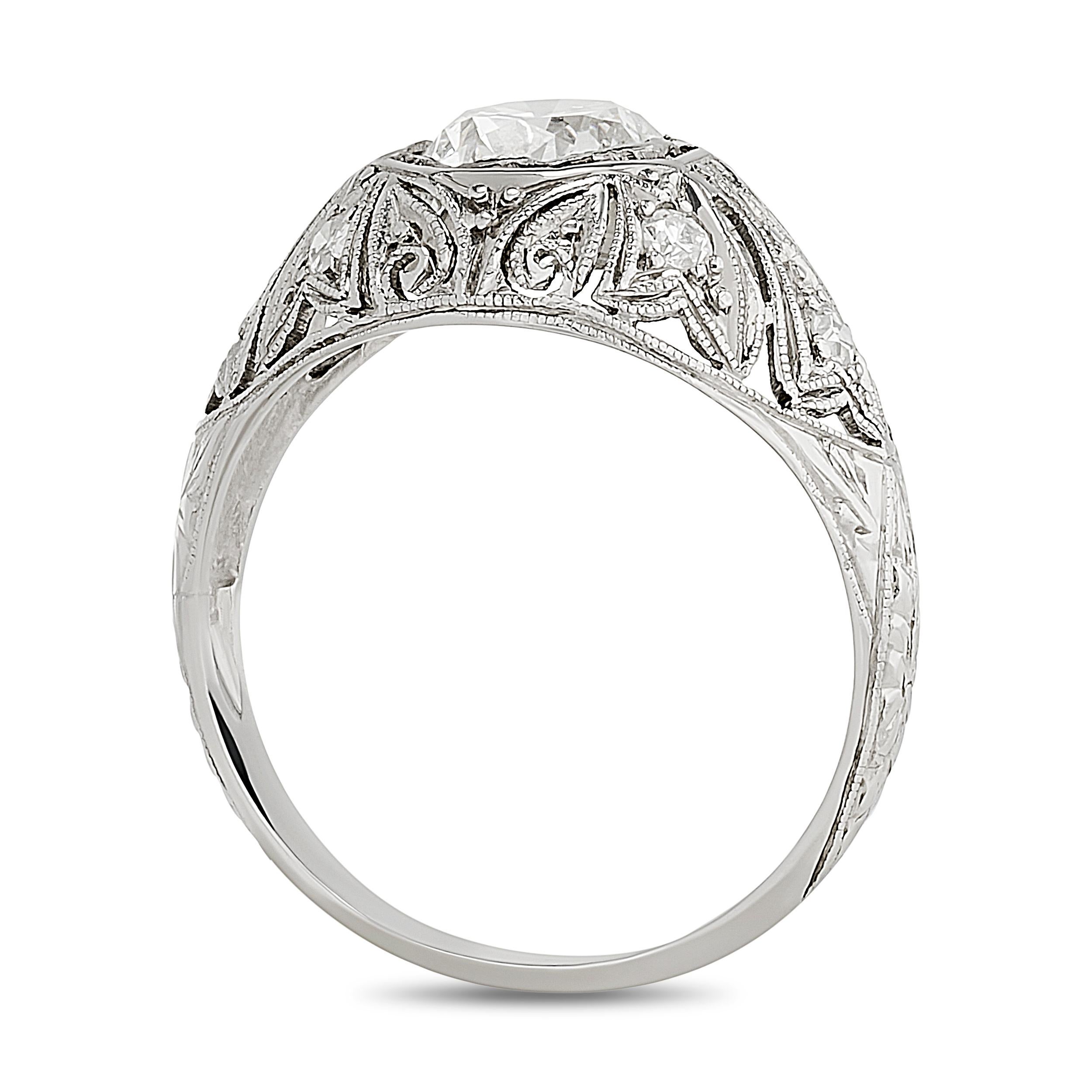 Cette bague en platine met en valeur un diamant rond de taille brillant dans une monture octogonale, entourée de détails ajourés et milgrainés complexes, incarnant une élégance délicate.

Diamant rond central - Environ 1,03 carat, couleur H et
