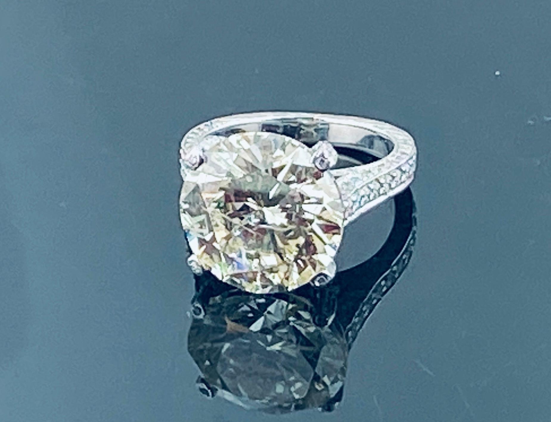Set in Platinum, weighing 11 grams, is one 10.32 carat Round brilliant Cut diamond, Color range of: L-M, clarity grade of SI-3.  the mounting is set with 154 Round Brilliant Cut diamonds for a total weight of 1.38 carats, Color Range of: F-G,