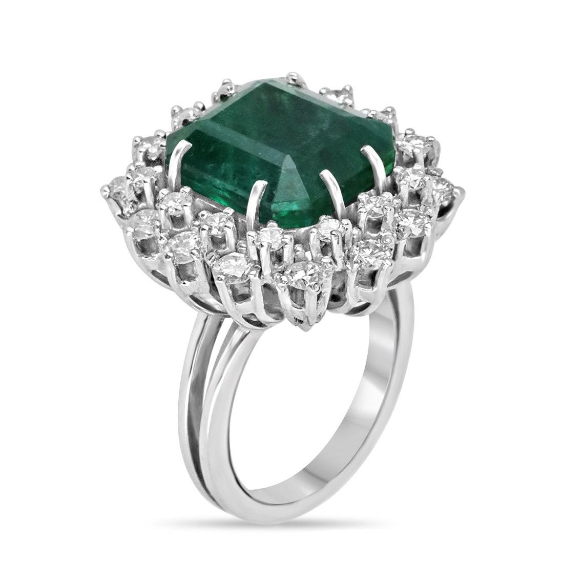 Introducing our exquisite Vintage Emerald and Diamond Cocktail Ring, a timeless masterpiece that captivates with a breathtaking 9.10-carat emerald cut emerald sourced from Zambia, showcasing a rich, deep sea green hue and semi-transparent clarity.