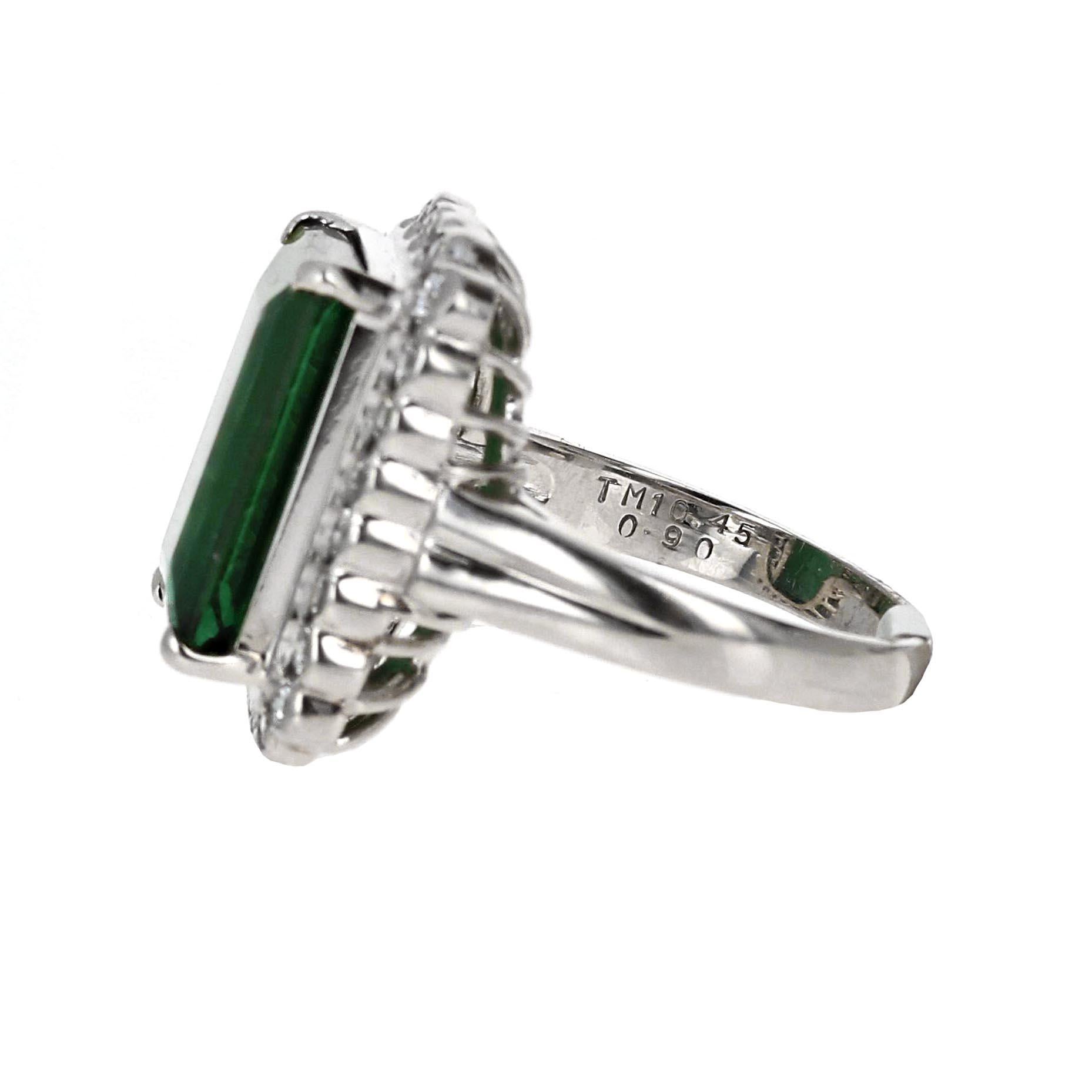Platinum 10.45 carat Tourmaline emerald cut cocktail ring adorned with 0.90 carats of dazzling diamonds. This magnificent piece combines the allure of a rare and vibrant 10.45 carat Tourmaline gemstone, expertly cut into an elegant emerald shape,