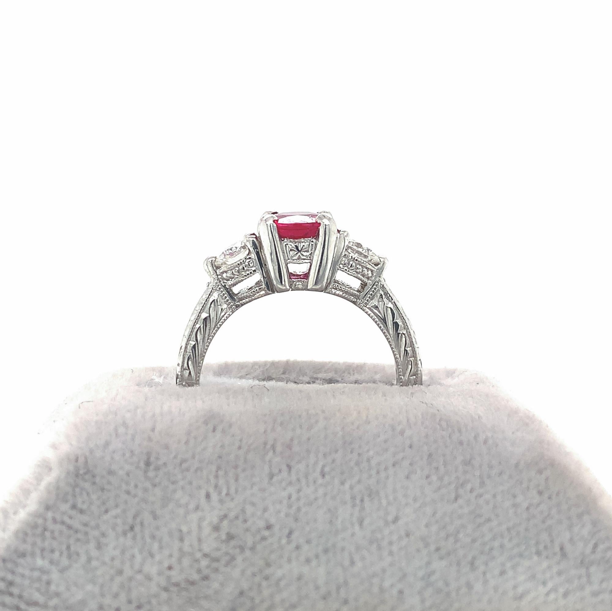 Top color GIA natural Burmese red ruby weighing 1.10 carats set in platinum. GIA report included. The ruby measures 6.69mm x 5.73mm is accented by 2 round brilliant cut diamonds weighing .45ct total. The platinum setting is hand engraved on 3 sides.