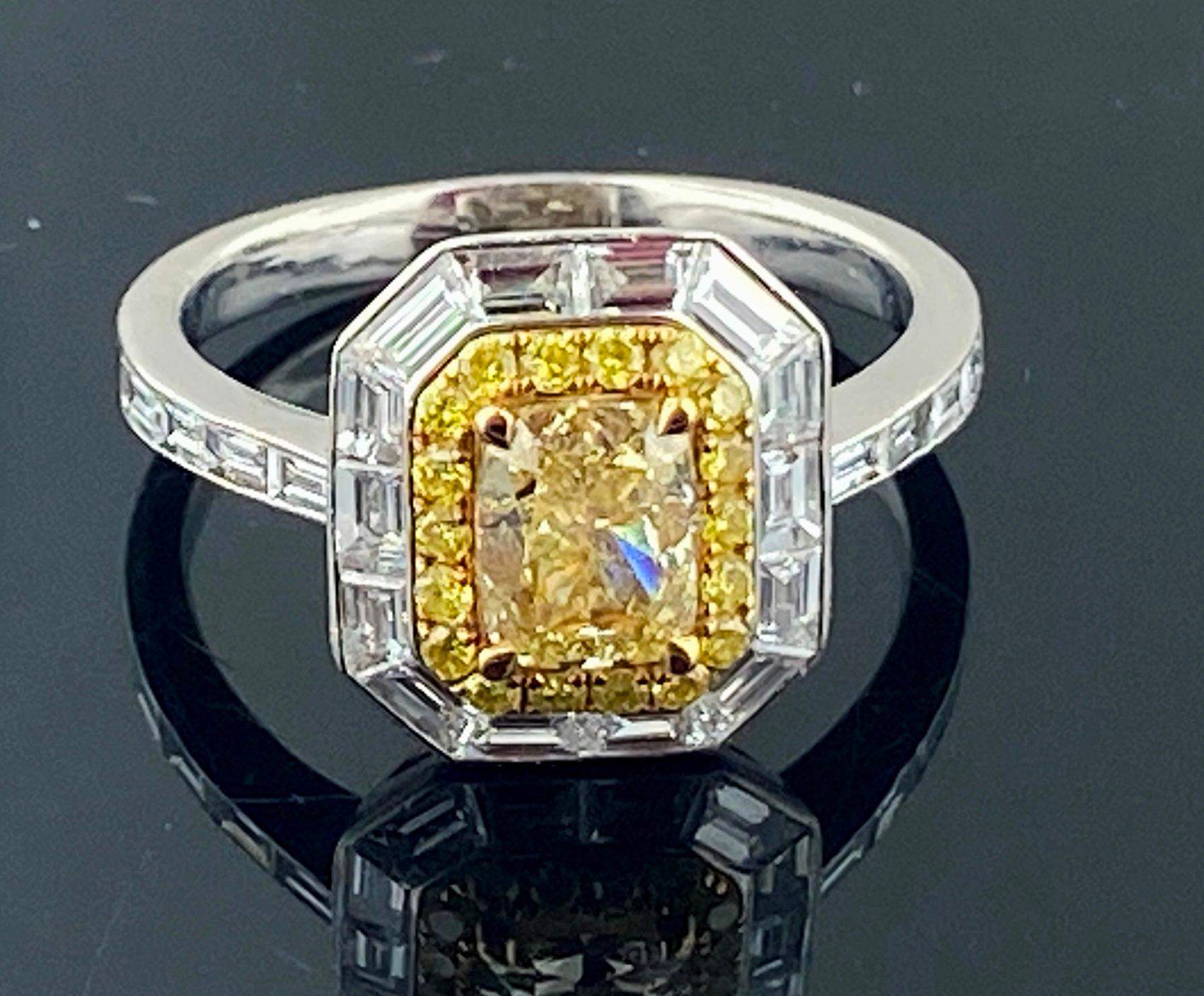 Set in Platinum, weighing 6.46 grams, is one 1.13 carat Cushion Cut Fancy Yellow Diamond, Clarity Grade of: VVS-1, GIA certificate # 2181175180.  Surrounding the center diamond are 18 Round Brilliant Cut Fancy Yellow diamonds, Clarity of: SI,
