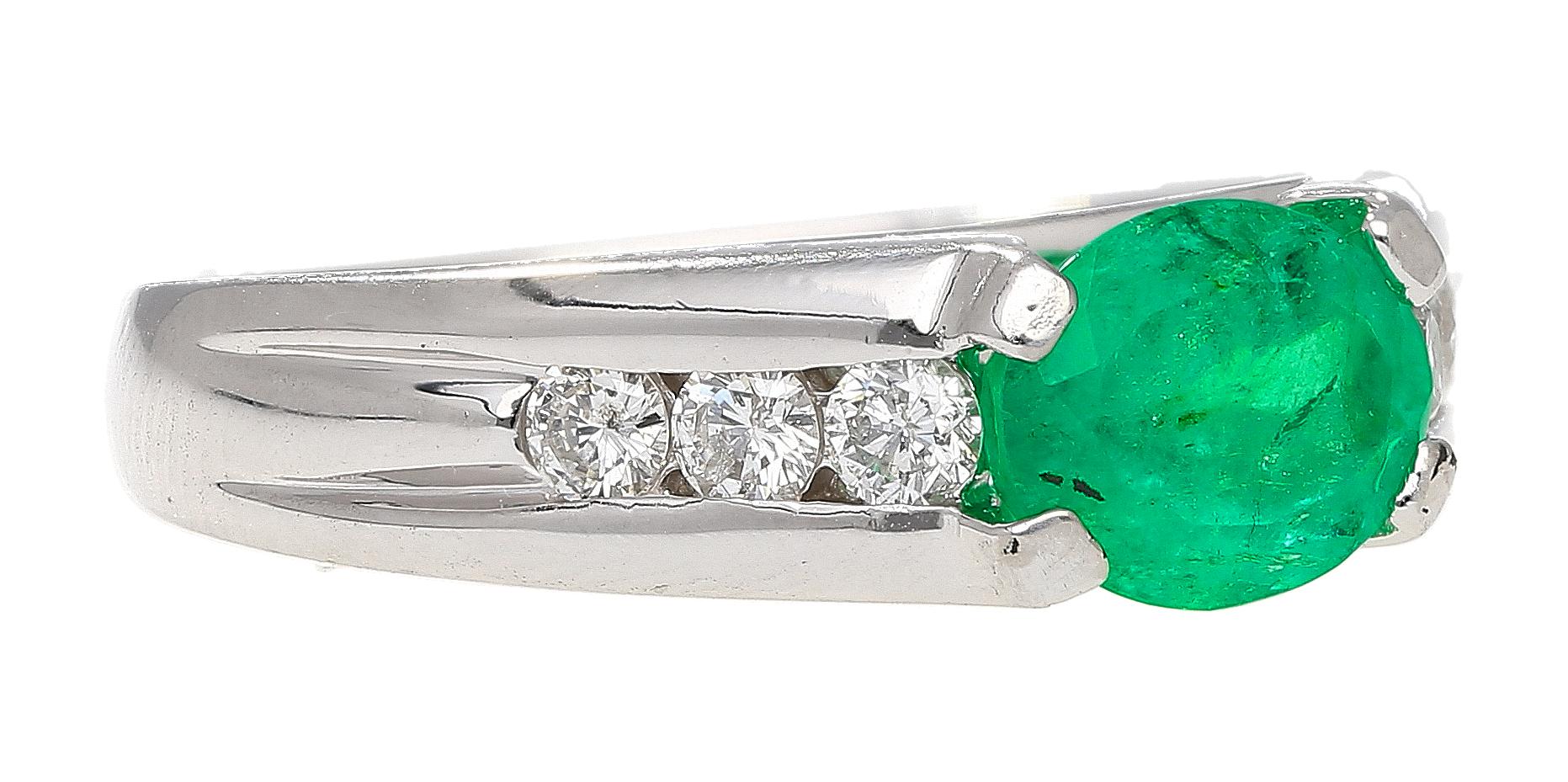 1.17 carat oval cut emerald ring, half bezel east west set with all natural mined gemstones. Adorned with 6 round cut diamonds, channel set, 3 on each side of the shank. The ring is all set in platinum, weighs 5.46 grams total, and is size US 6.5.