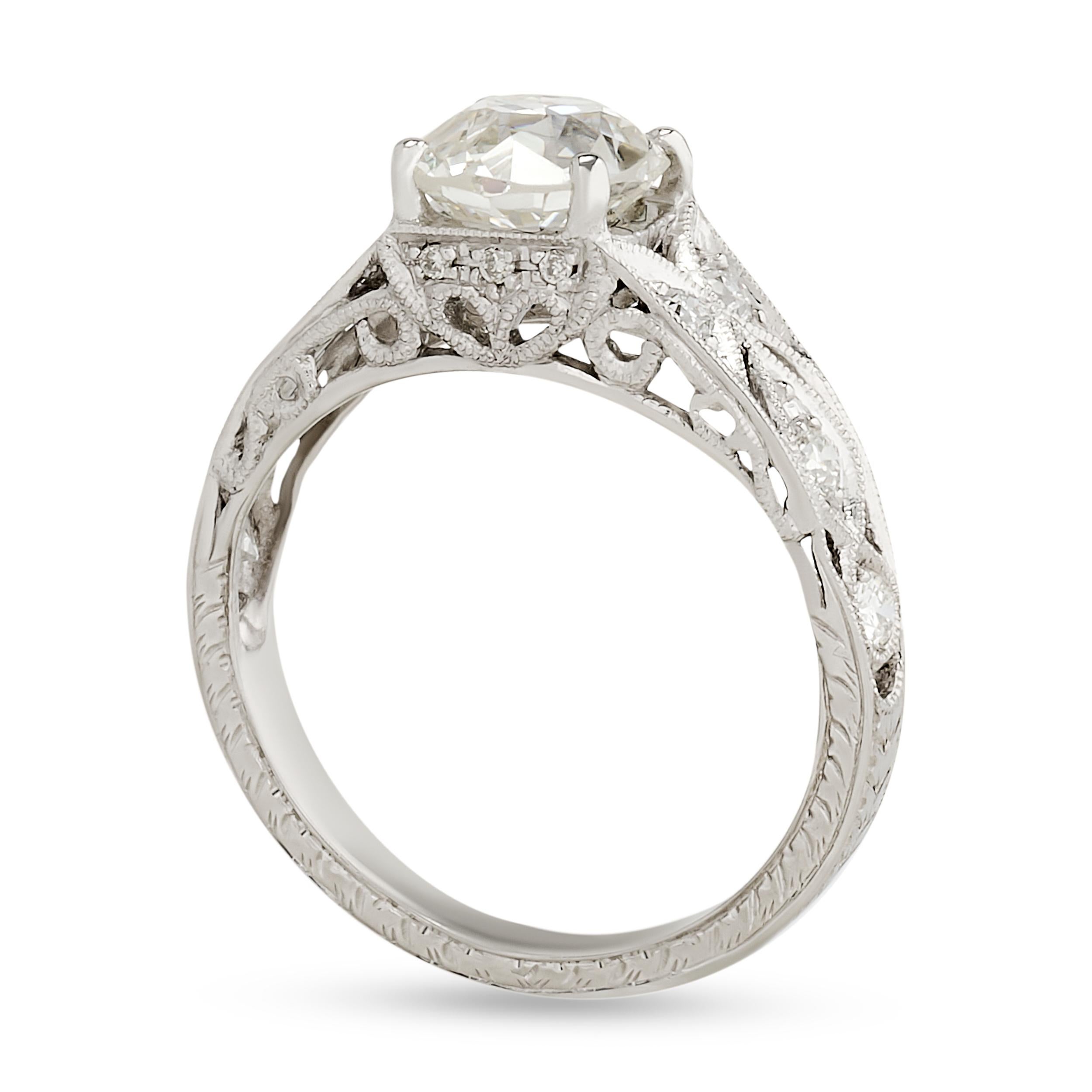 This platinum ring showcases an old mine cut diamond in a low, bezel-like setting, flanked by delicate, pierced shoulders with diamond accents and milgrain detailing, embodying  romantic elegance.

Center Old Mine Cushion Cut Diamond - Approximately