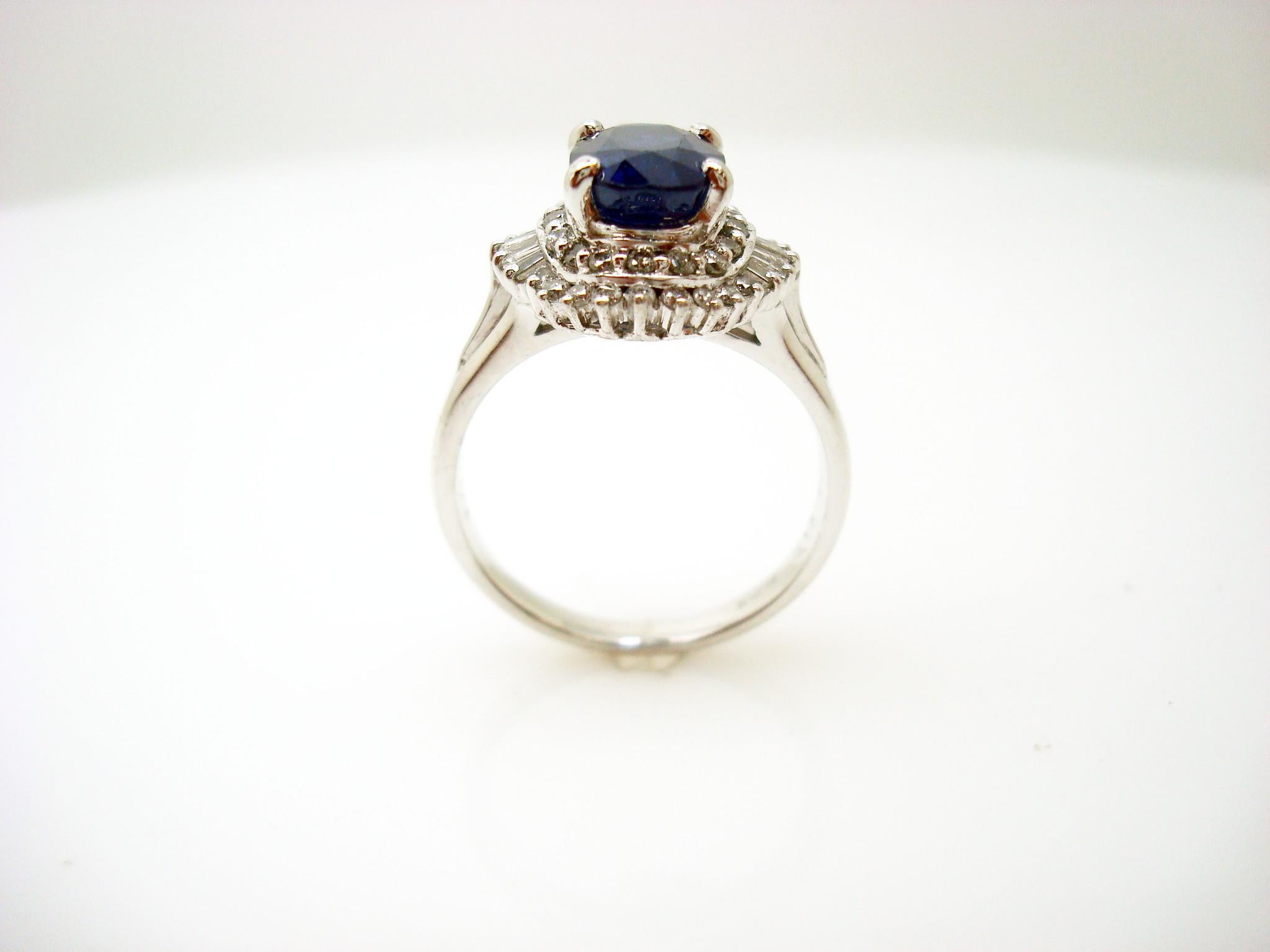 Platinum sapphire and diamond ring featuring a large oval blue sapphire weighing 1.42 carats. The sapphire is accented by .40cts total of round and baguette cut diamonds set in a ballerina style.  The sapphire measures 8.6mm x 6.4mm.  The round