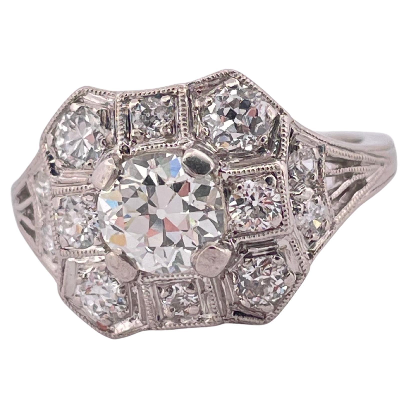 Dieser exquisite Platinring zeigt die Eleganz und Handwerkskunst einer vergangenen Ära und ist mit insgesamt 1,47 Karat schillernden Diamanten besetzt. In seinem Zentrum ruht ein heller Diamant im alten europäischen Schliff, der von einem