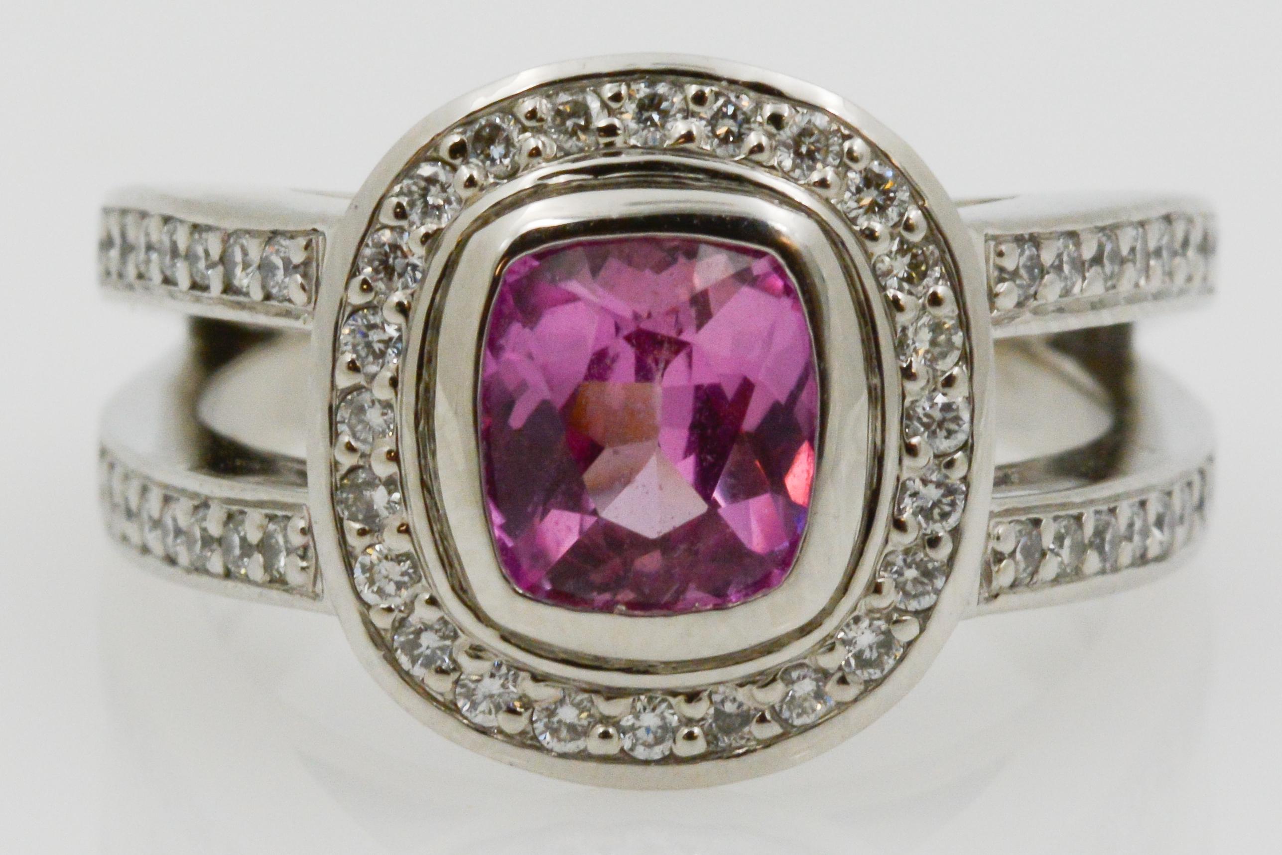 Oh so pink and truly romantic, celebrate the love you share with this captivating ring. Set in Platinum with a mesmerizing 1.48ctw cushion cut pink sapphire center stone with an enchanting halo of round brilliant diamonds. This ring is further