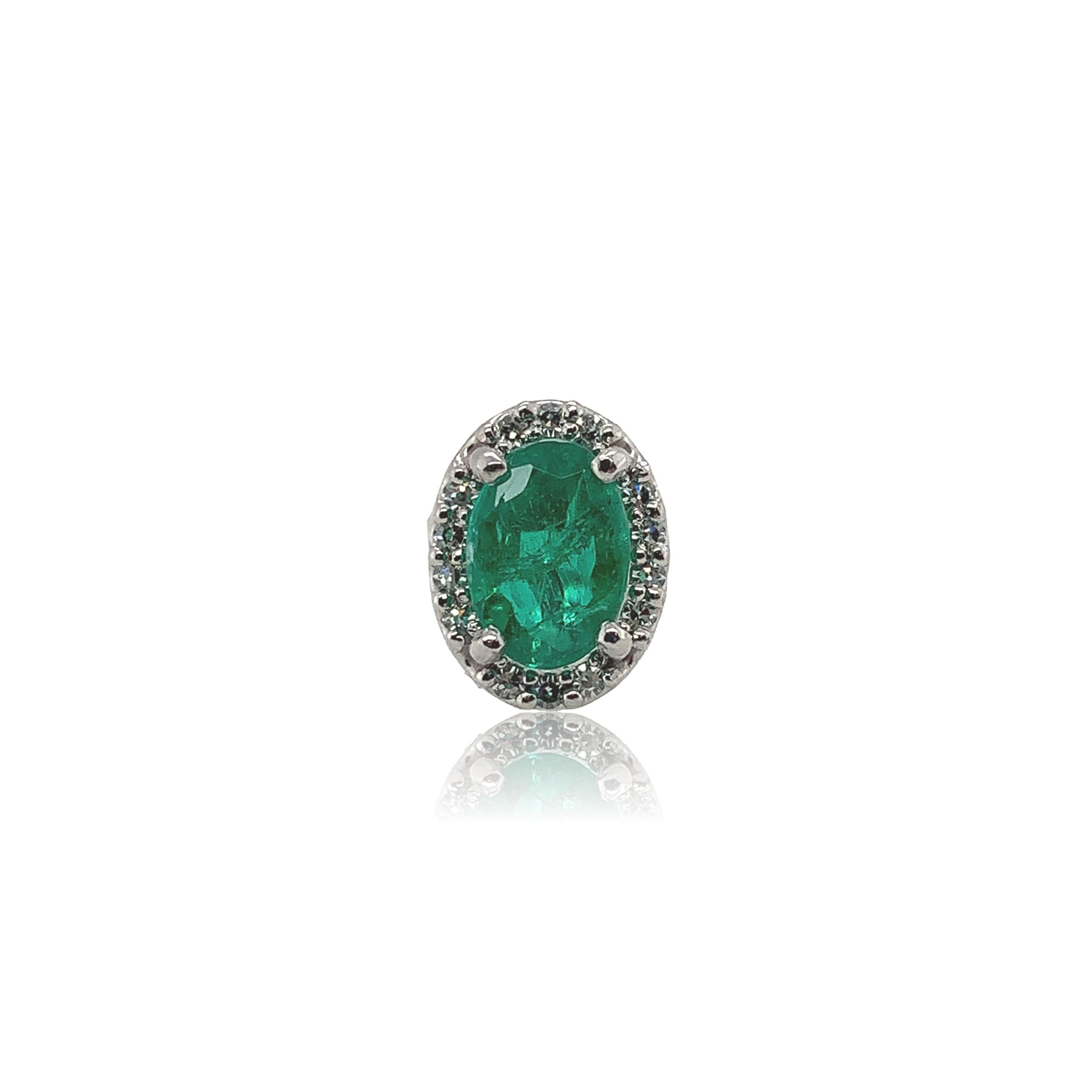 A pair of platinum genuine earth mined emerald stud earrings with diamond halos. The oval cut emeralds measure about 7mm x 5mm and have medium dark color and fine clarity. The emeralds weigh 1.48 carats total. There are 28 tiny round diamond accents