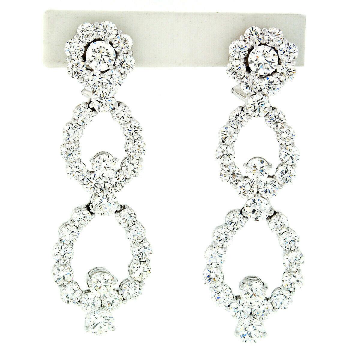 This breathtaking pair of statement diamond dangle earrings is crafted in solid platinum and features approximately 14.92 carats of very fine quality round brilliant cut diamonds throughout. These diamonds sparkle like no others with near colorless